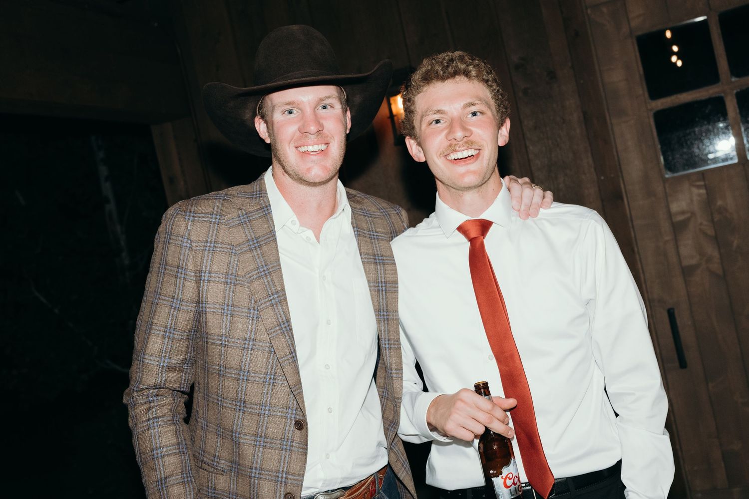 Wedding guests in formal attire and cowboy hats enjoying the celebration.