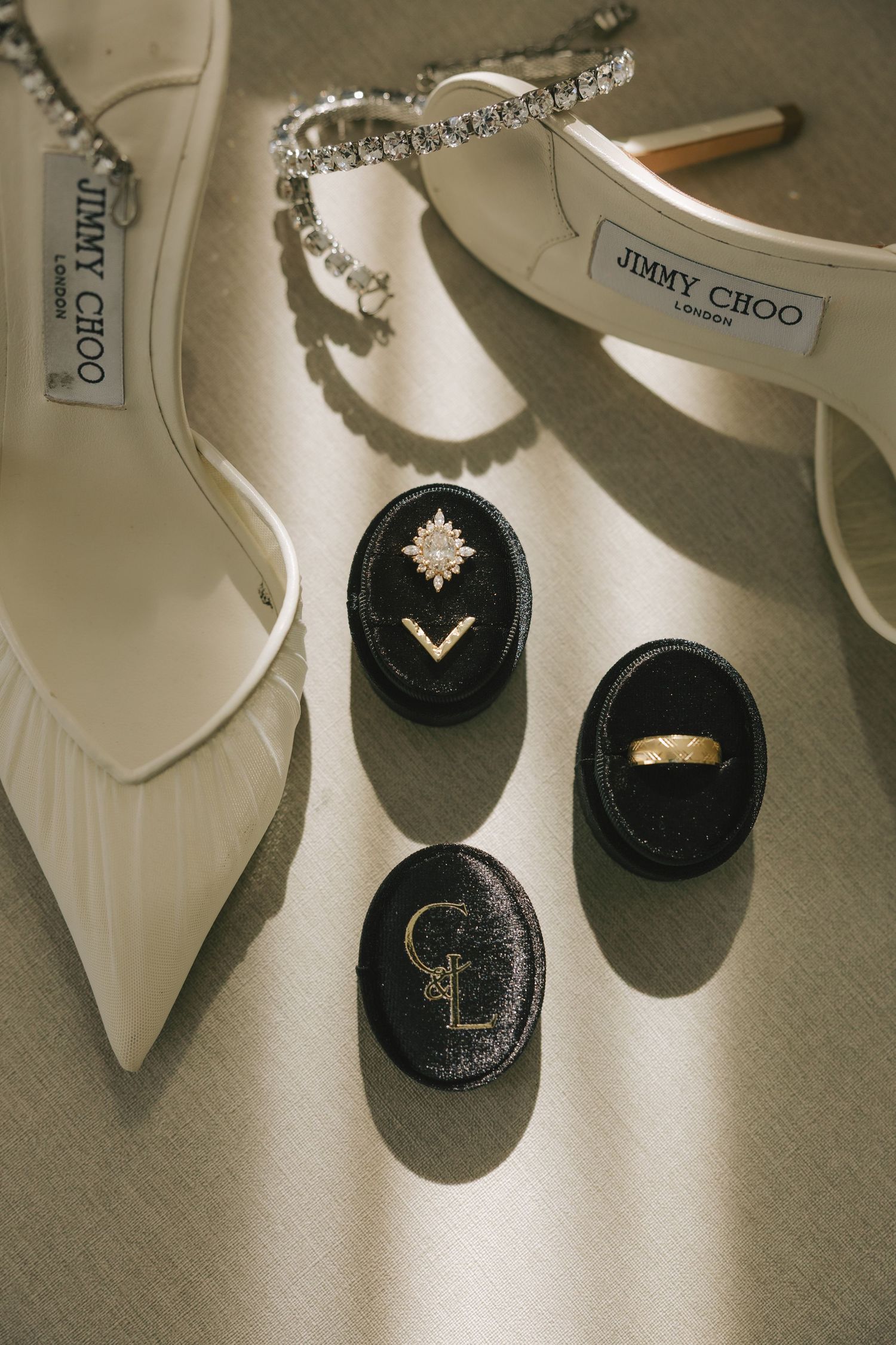 Elegant white Jimmy Choo bridal shoes with crystal embellishments displayed against a neutral background.