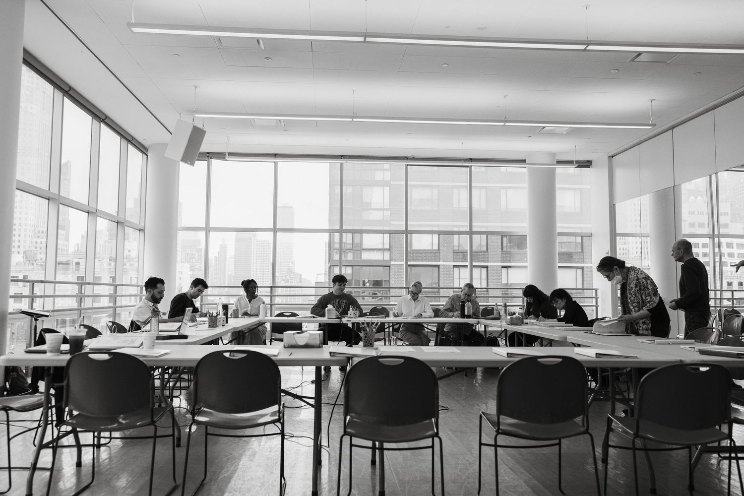Wide angle view of empty classroom with chairs and large windows.
