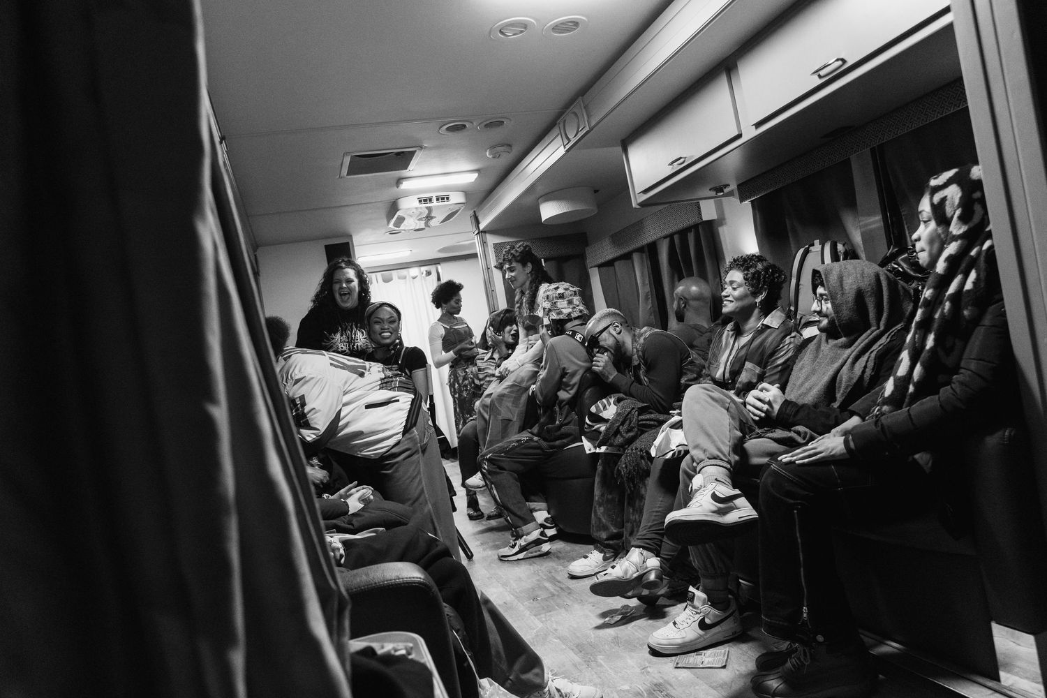 A group sits together in what appears to be a train car or narrow corridor.