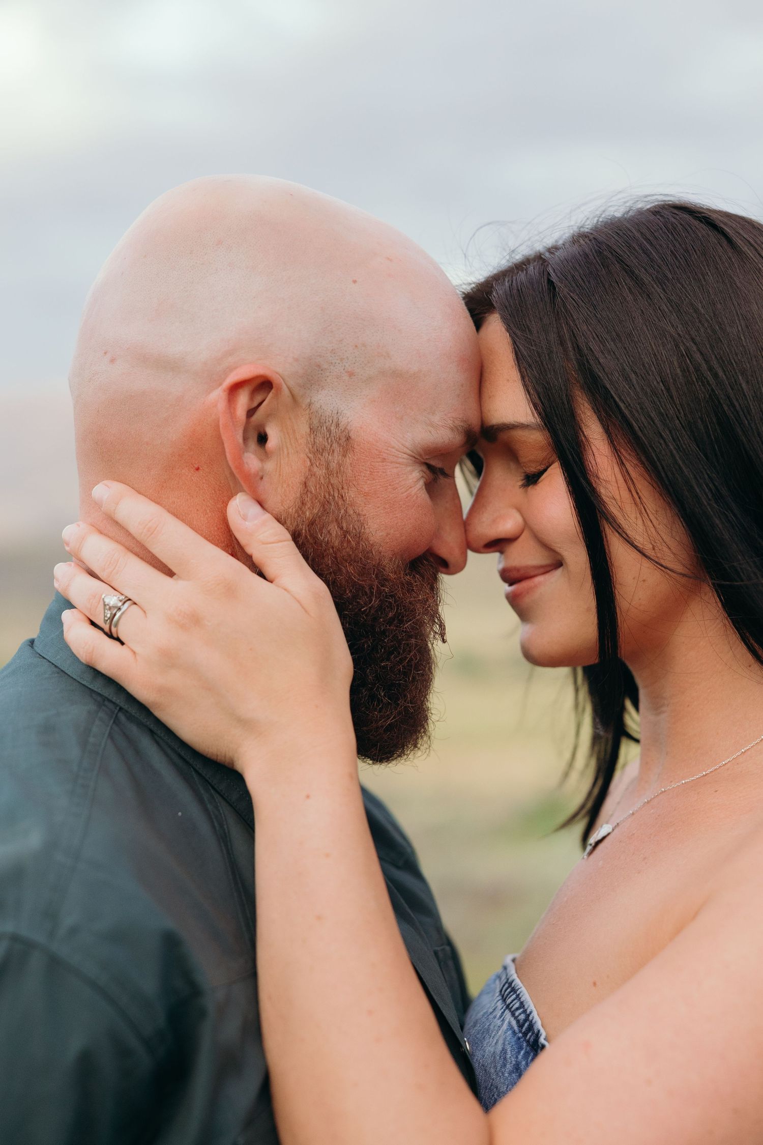 A close-up shot captures an intimate moment between a bearded person and partner.