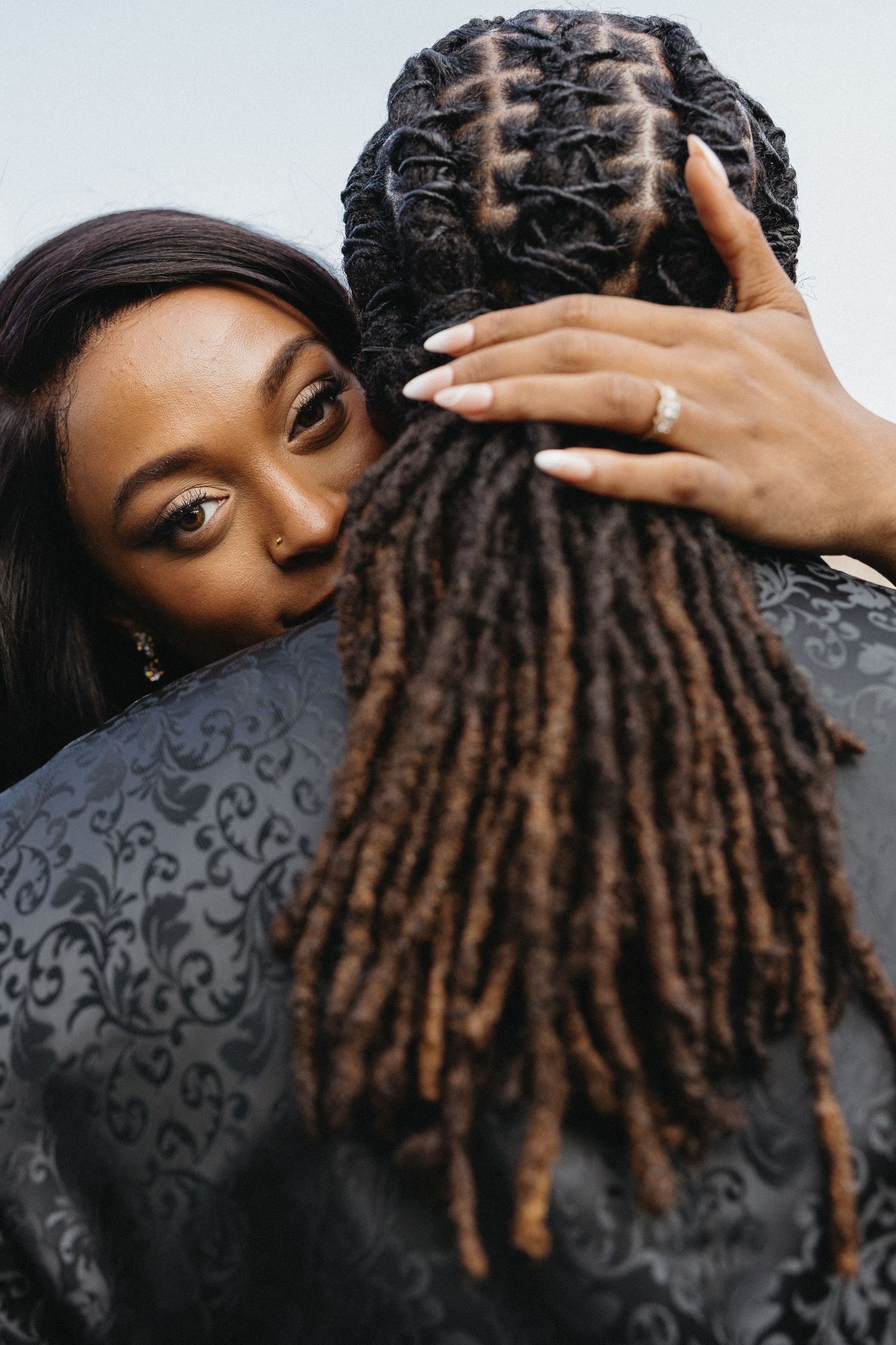 Artistic close-up shots of hands running through dreadlocks against dark fabric.