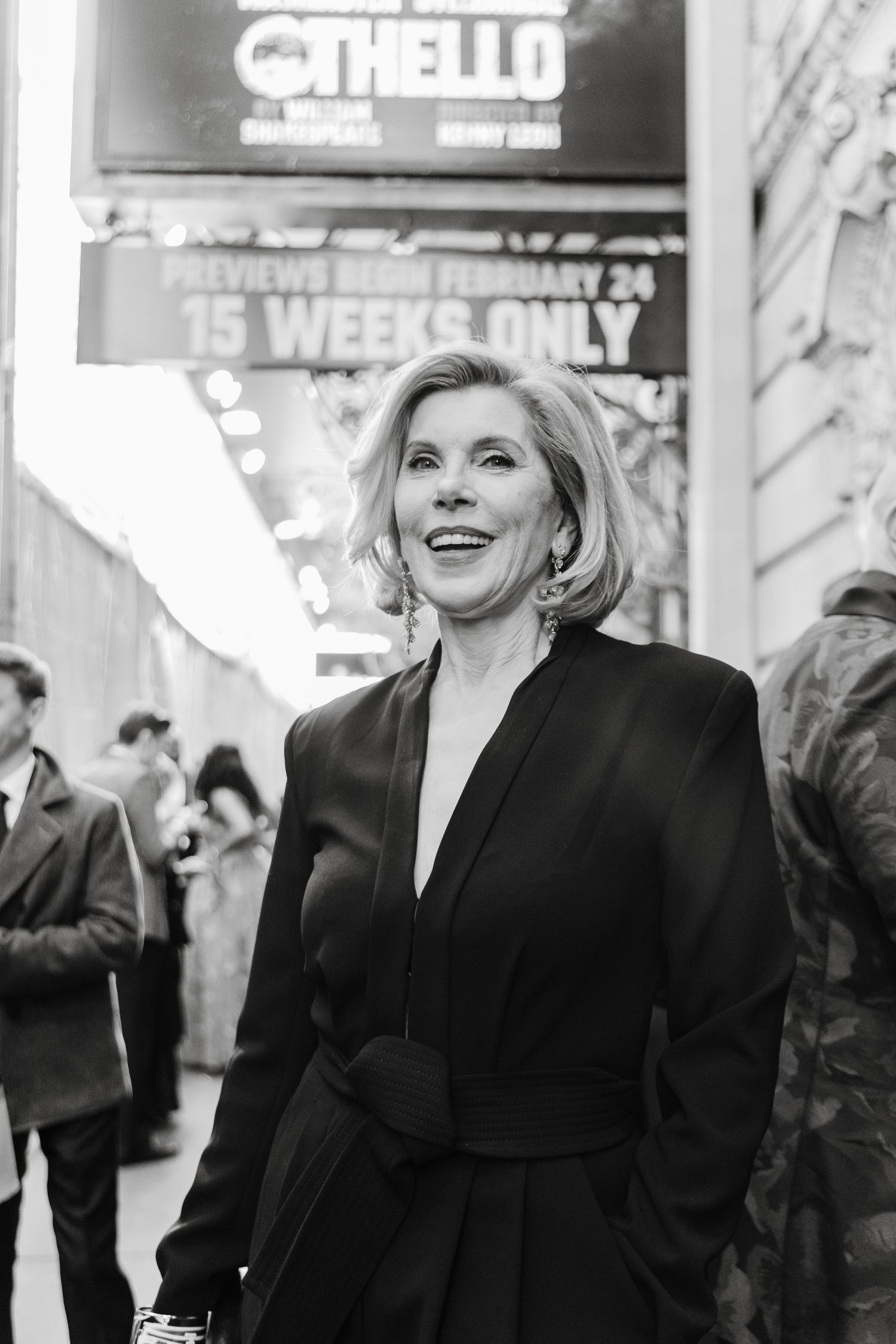 Elegant woman in a black blazer smiling at a formal event.