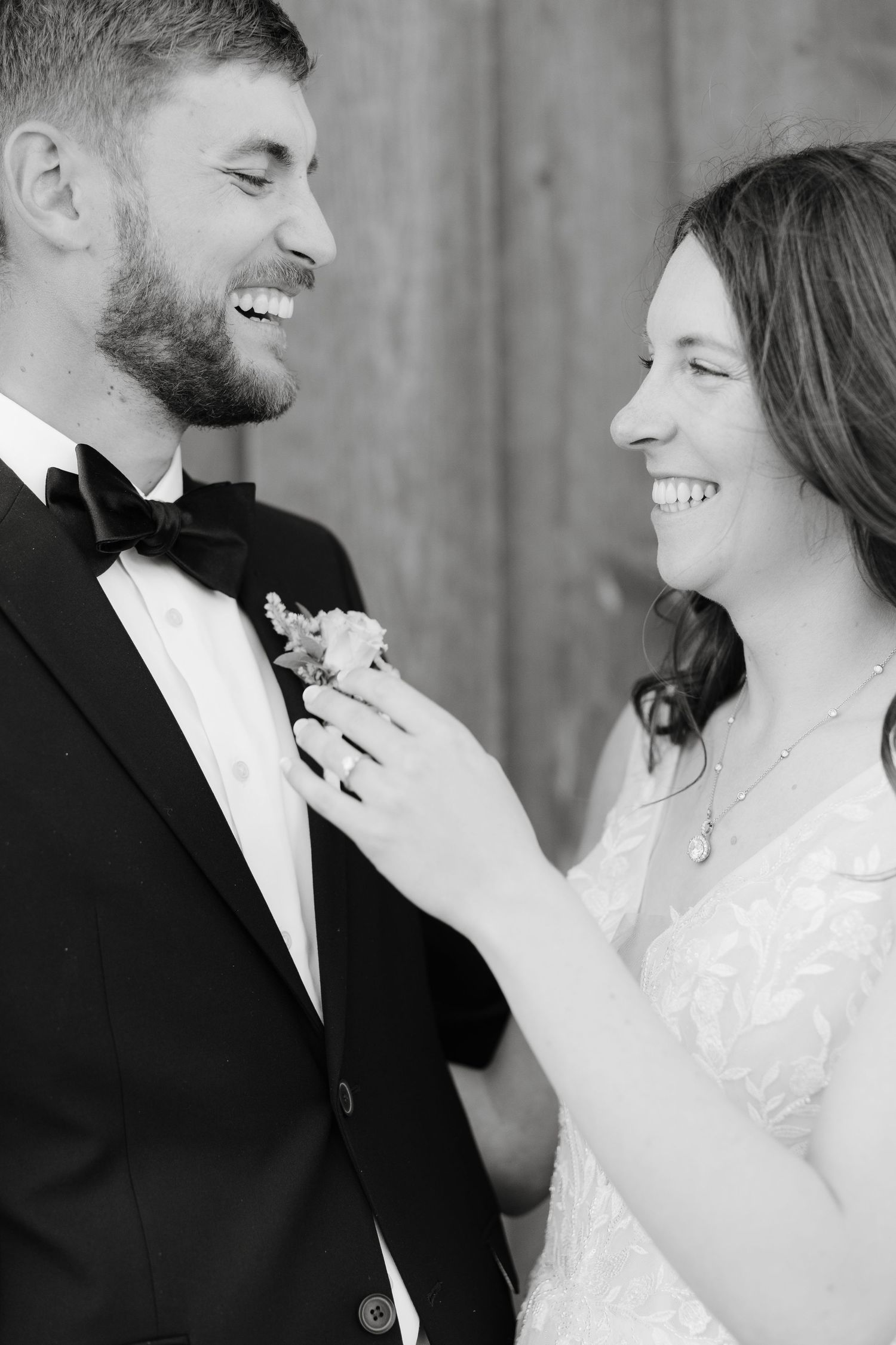 Black and white portraits capture intimate moments between newlyweds against a wooden backdrop.