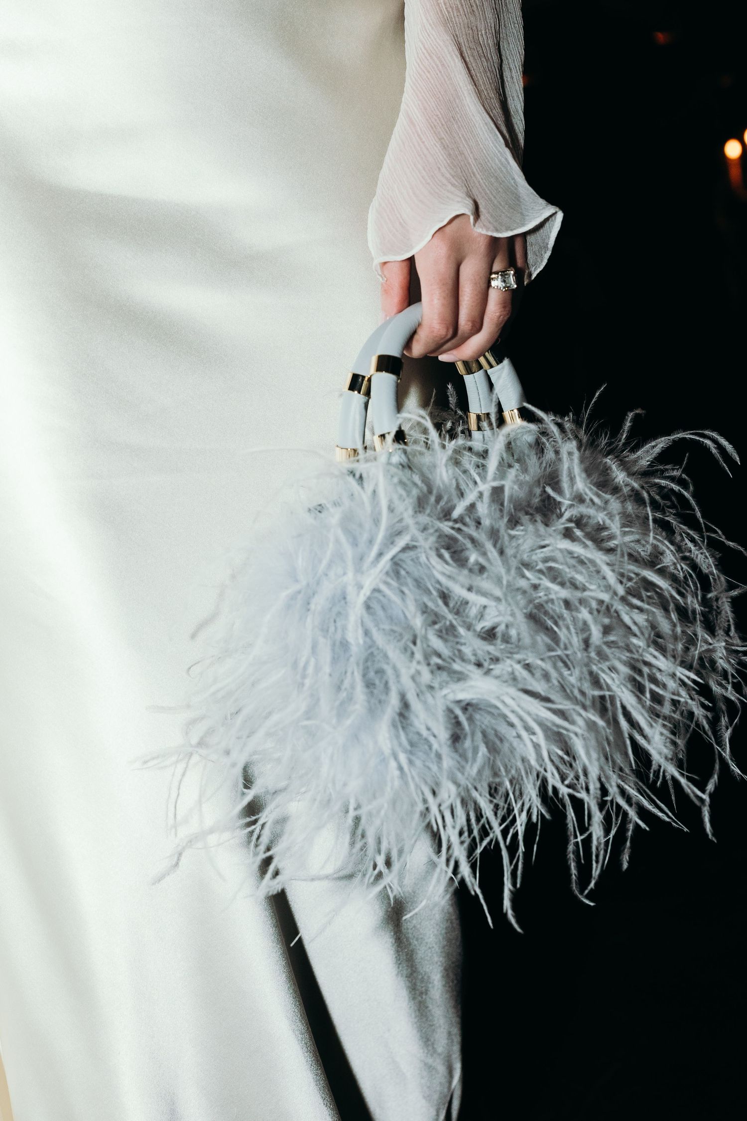 A luxurious light gray feather handbag with ostrich plumes creates an elegant and dramatic fashion statement.
