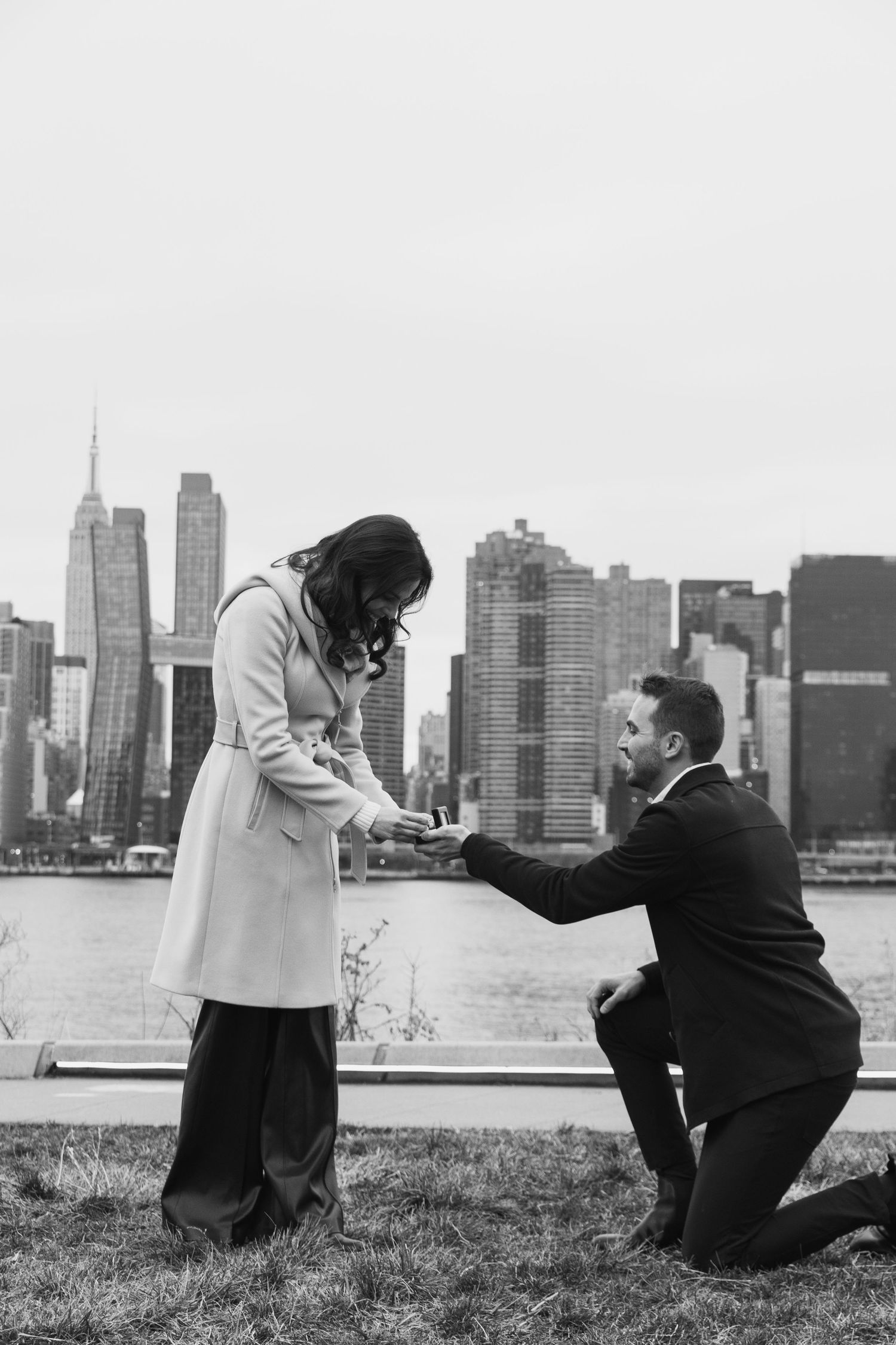 A series of black and white photos showing a romantic proposal scene with a city skyline backdrop.