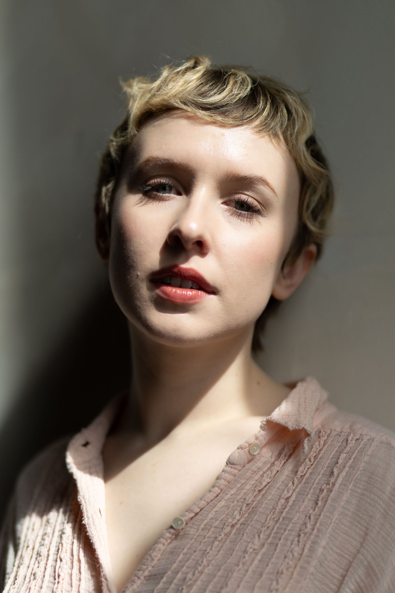 Artistic portrait series showing dramatic lighting and red lipstick against a neutral background.