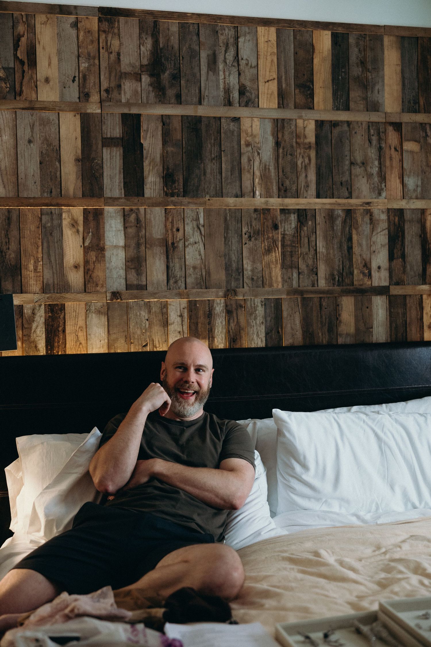 Sequential shots of a person resting on a bed with rustic wooden wall panels in the background.