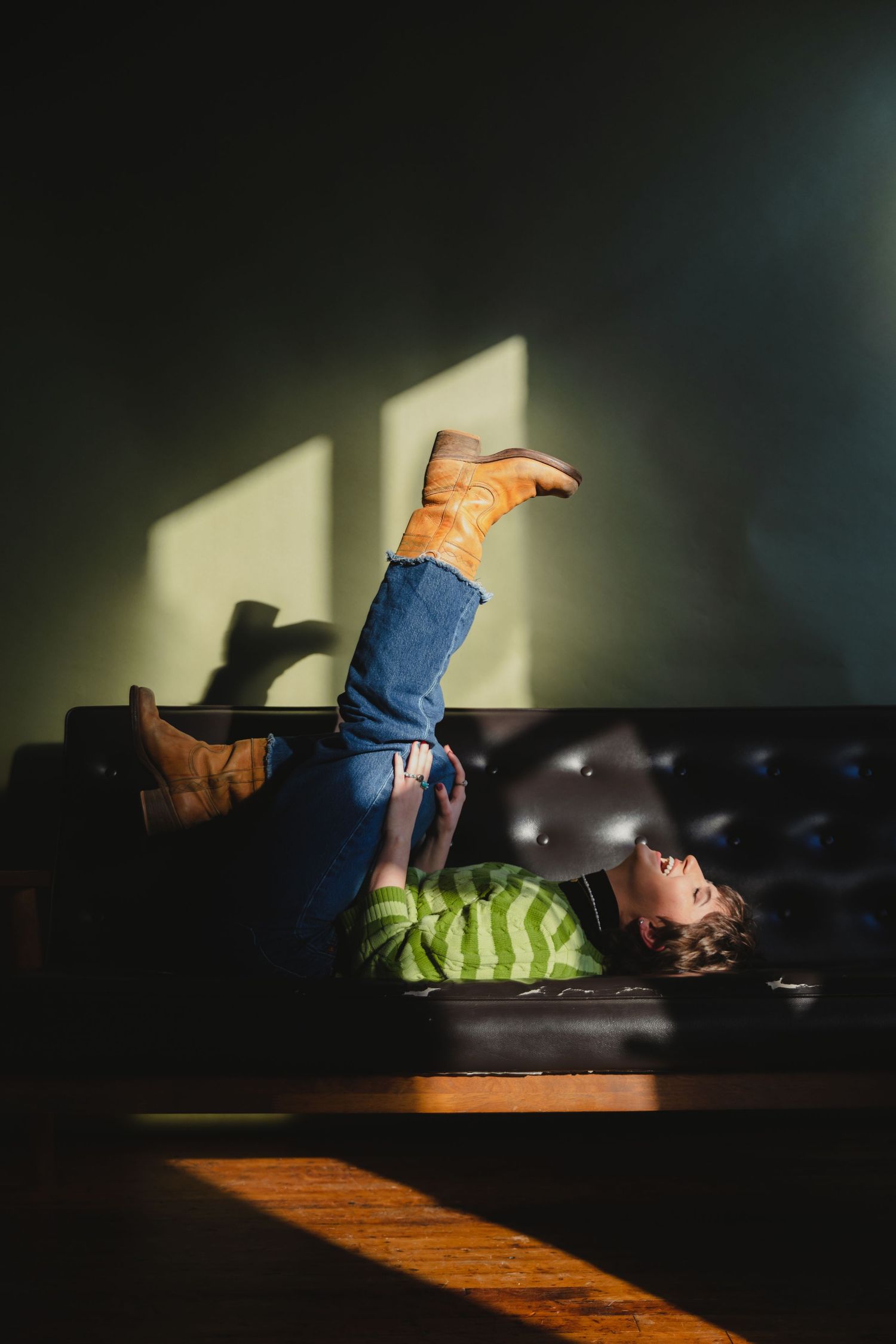 A sequence of images shows a person rolling and tumbling on a dark leather couch in dramatic lighting.