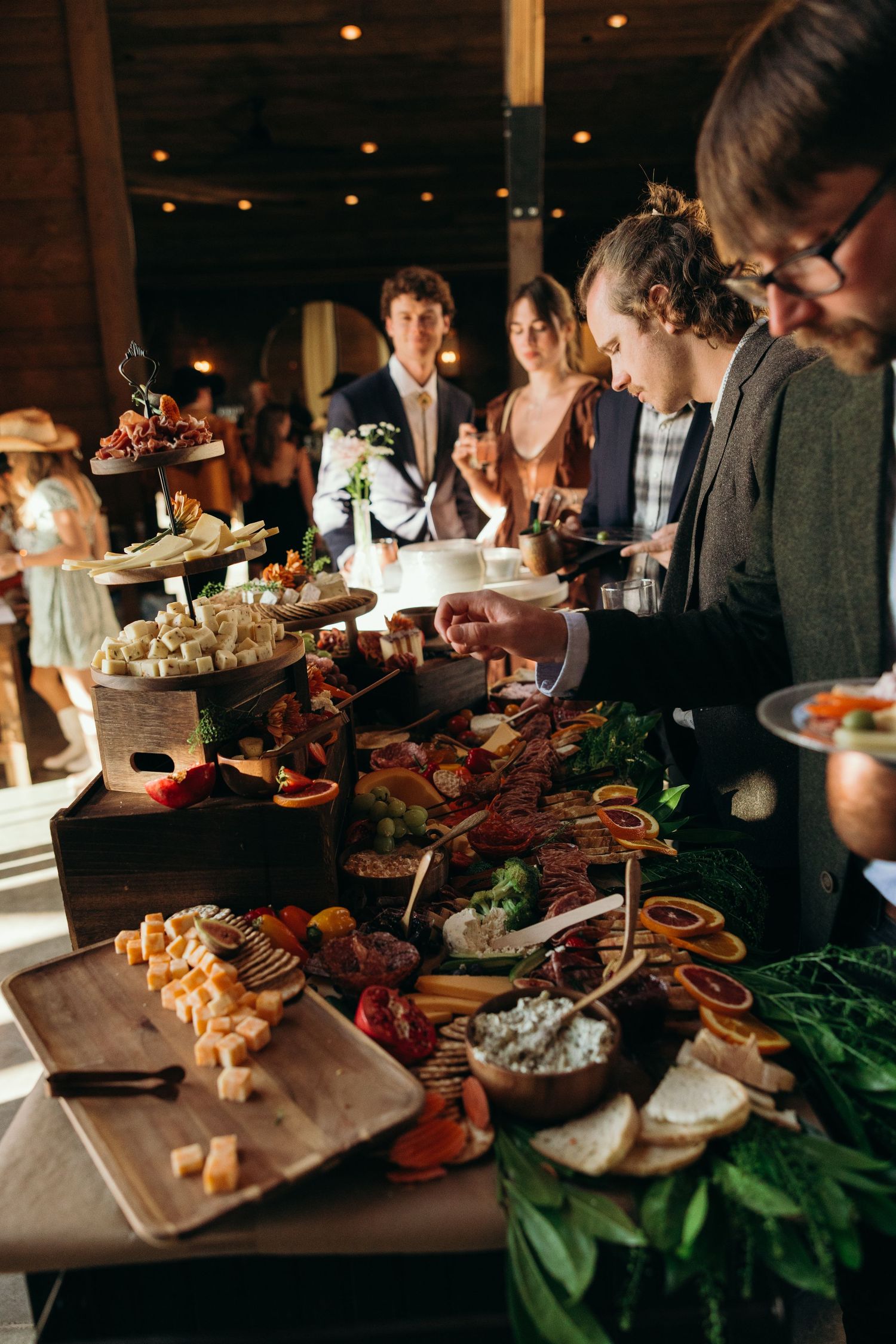 Elegant wedding reception buffet table with gourmet appetizers and mood lighting.