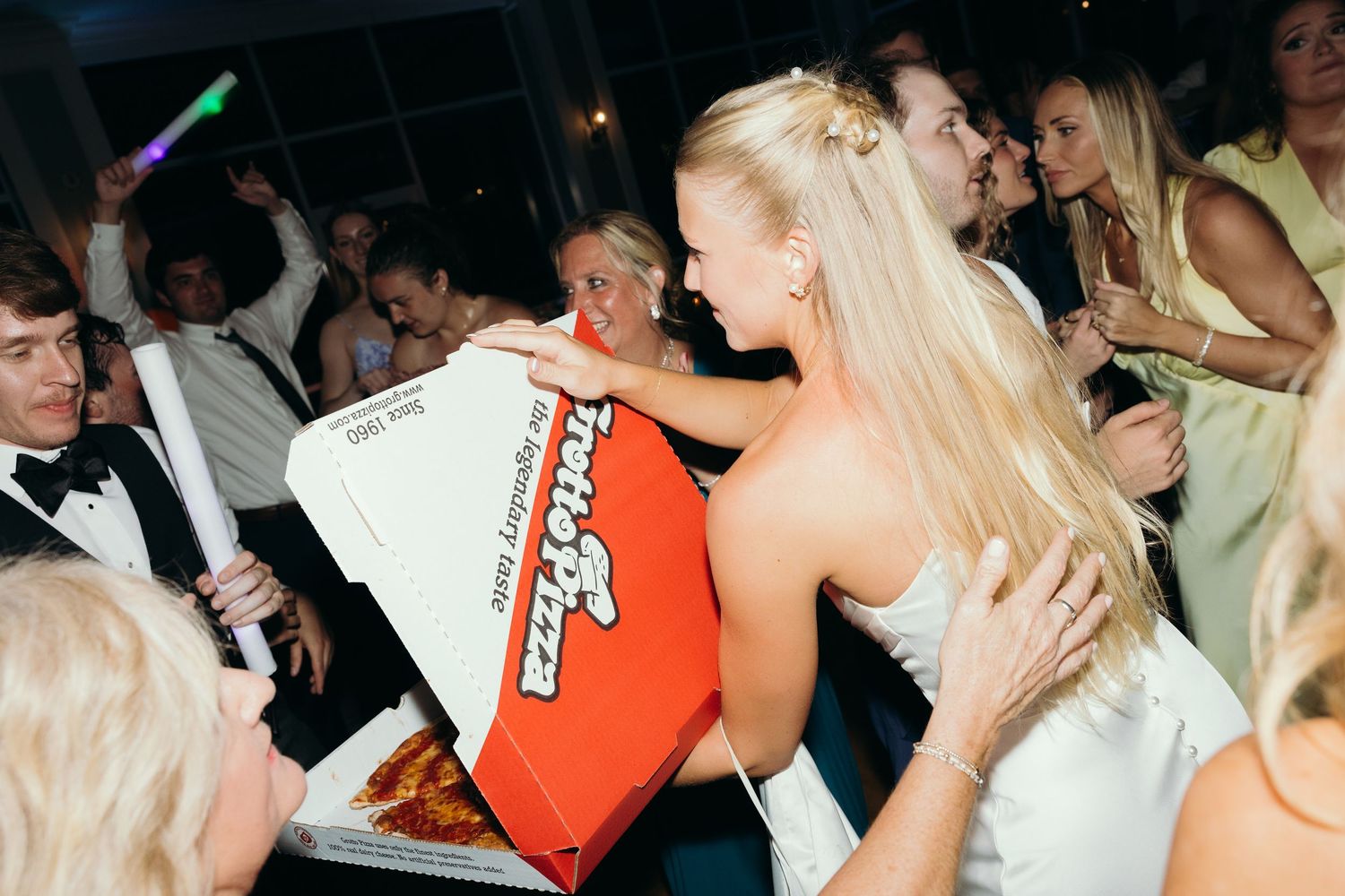 Energetic dancing and celebration at a wedding reception with guests in formal attire.
