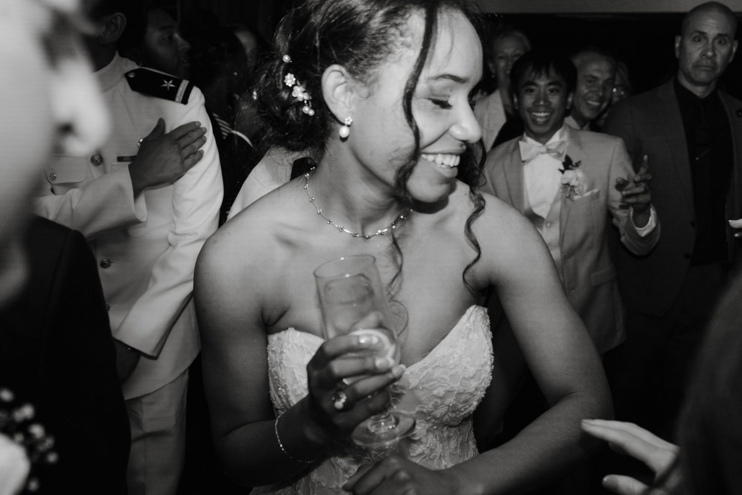 Wedding reception dance floor filled with guests celebrating in black and white photography.