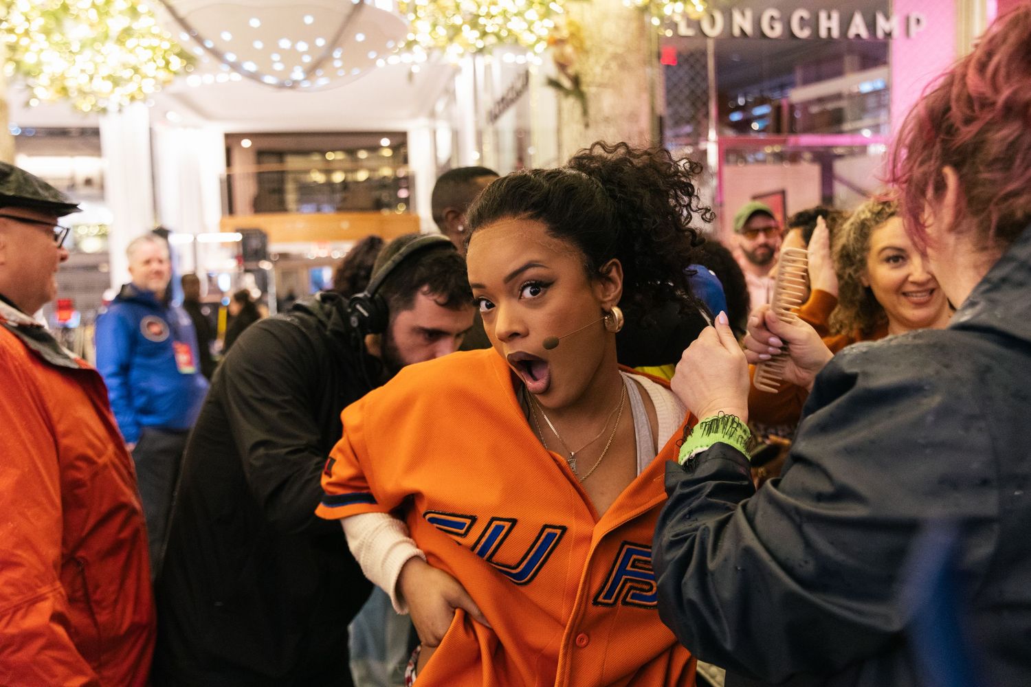 A vibrant street celebration scene with people dancing under bright city lights.