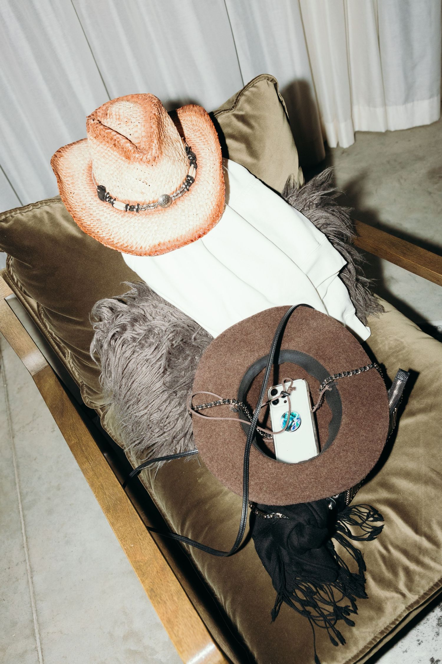 Two cowboy hats with decorative feathers displayed on a cushioned surface.