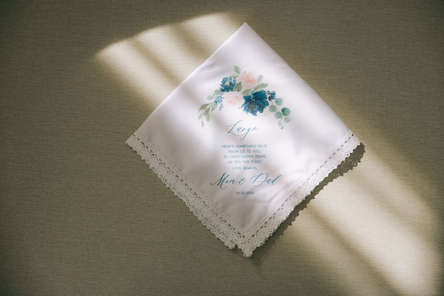 A series of white linen napkins with delicate embroidered details and scalloped edges arranged in a row.