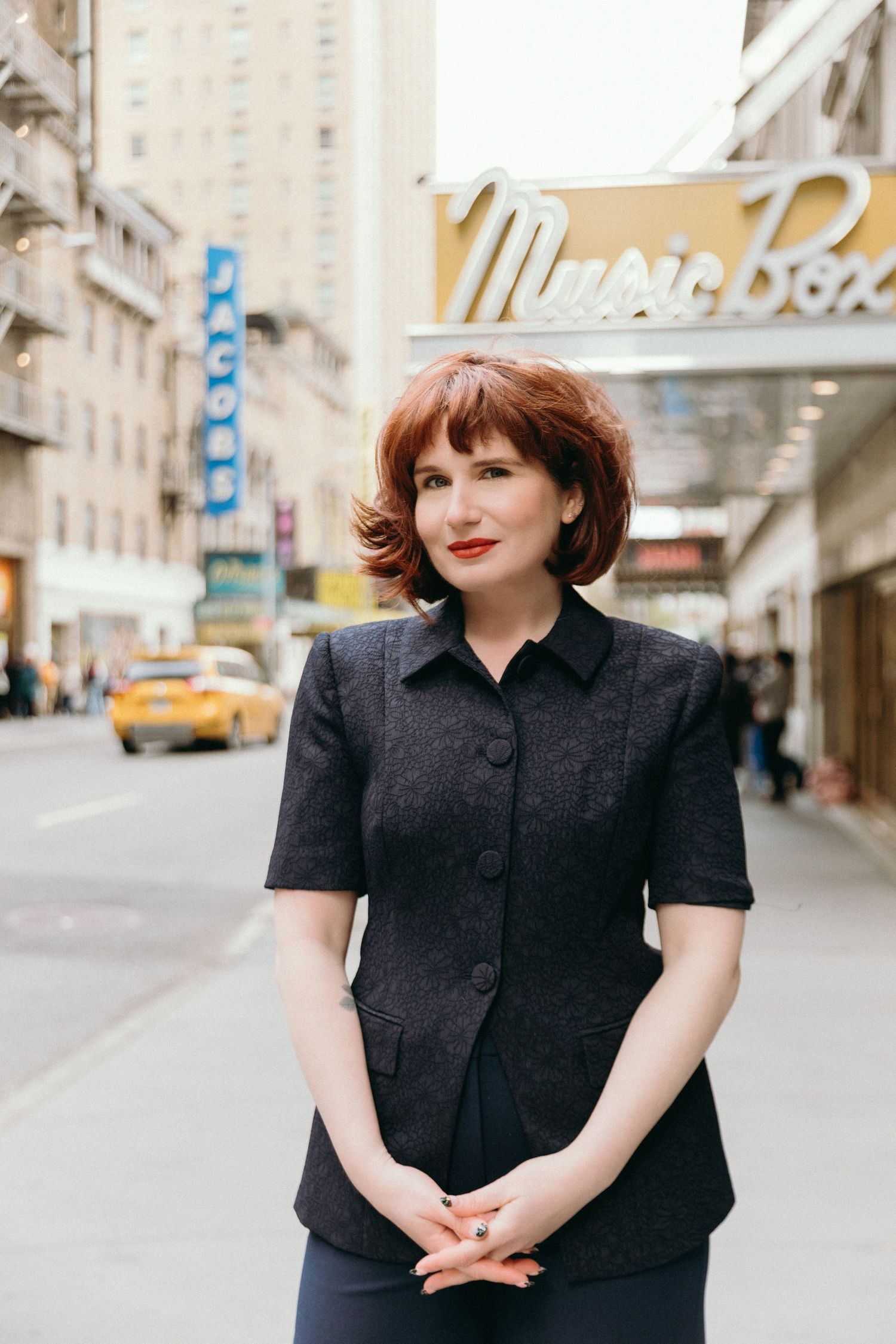 A series of four street fashion photos showing someone in a classic black button-up dress against an urban backdrop.