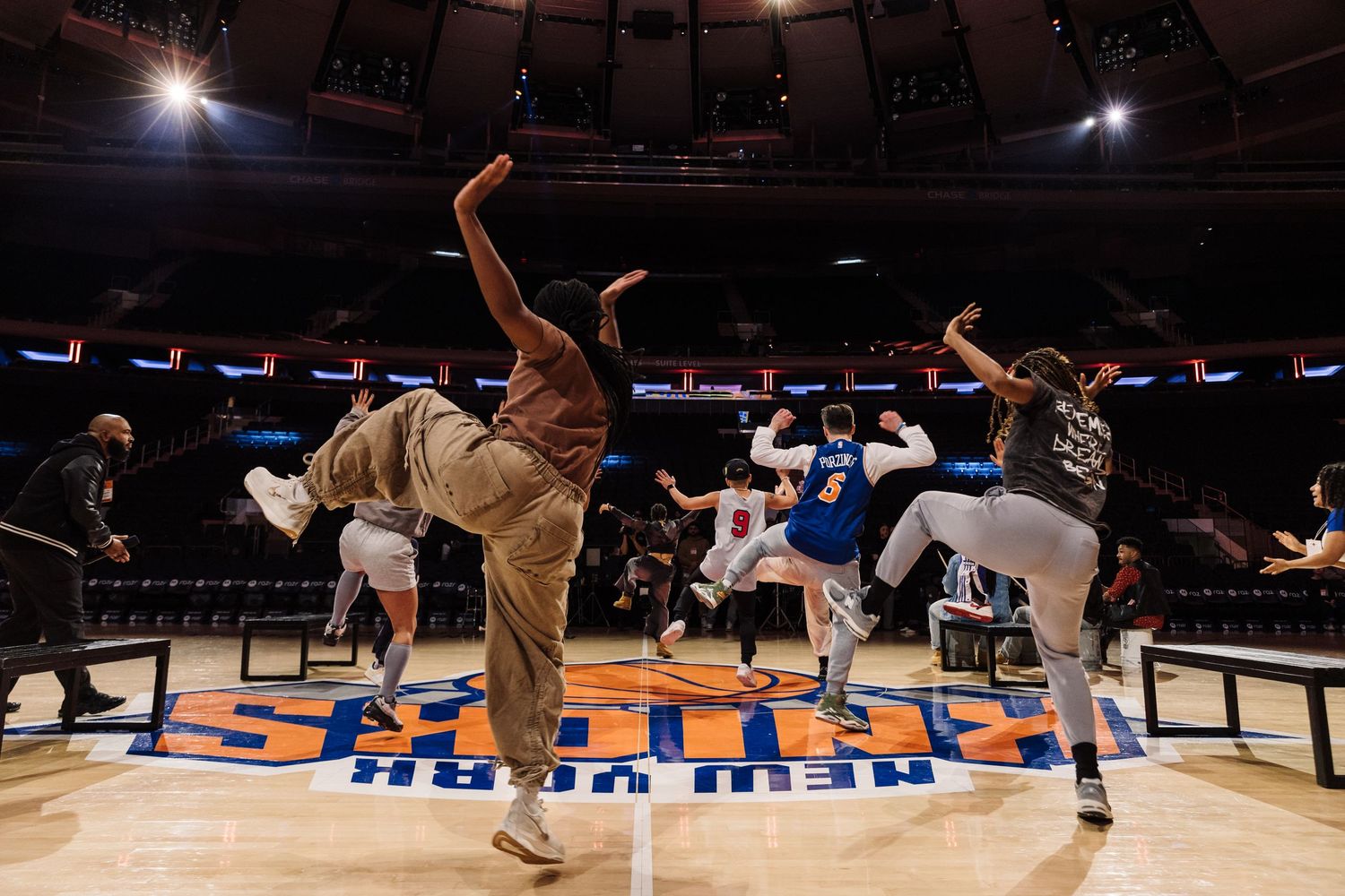Basketball fans cheer excitedly in an arena during an intense game moment.