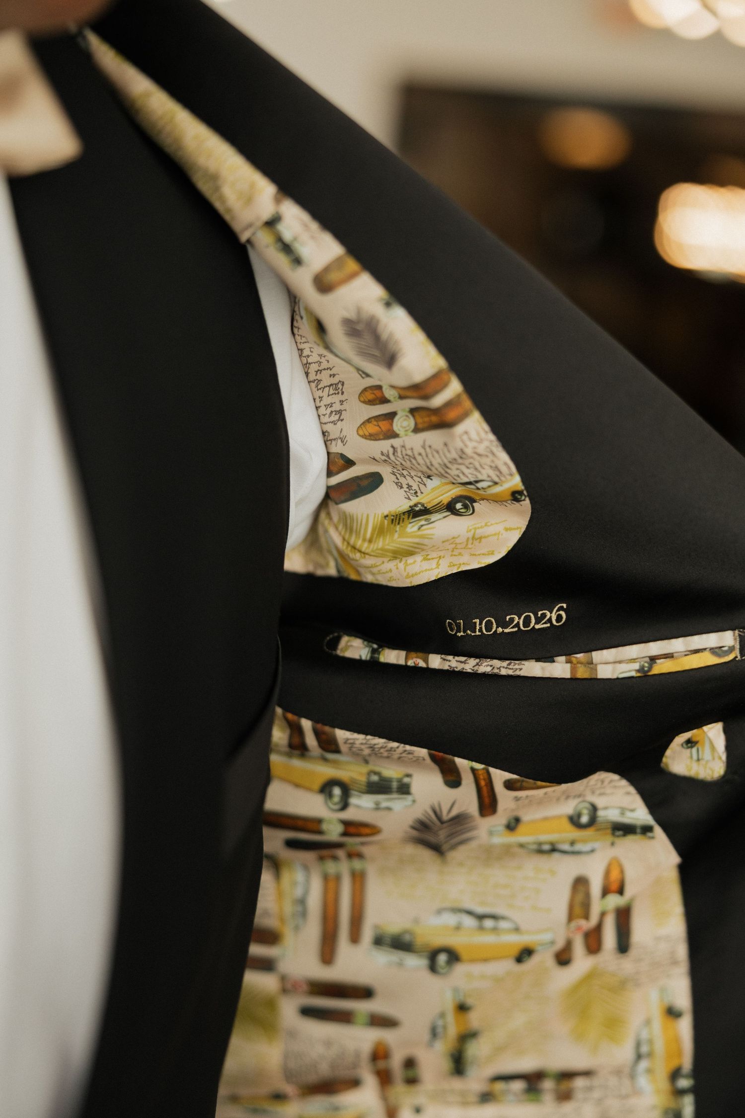 Close-up detail of a suit jacket lining featuring a vintage-style print pattern with yellow cars and retro designs.