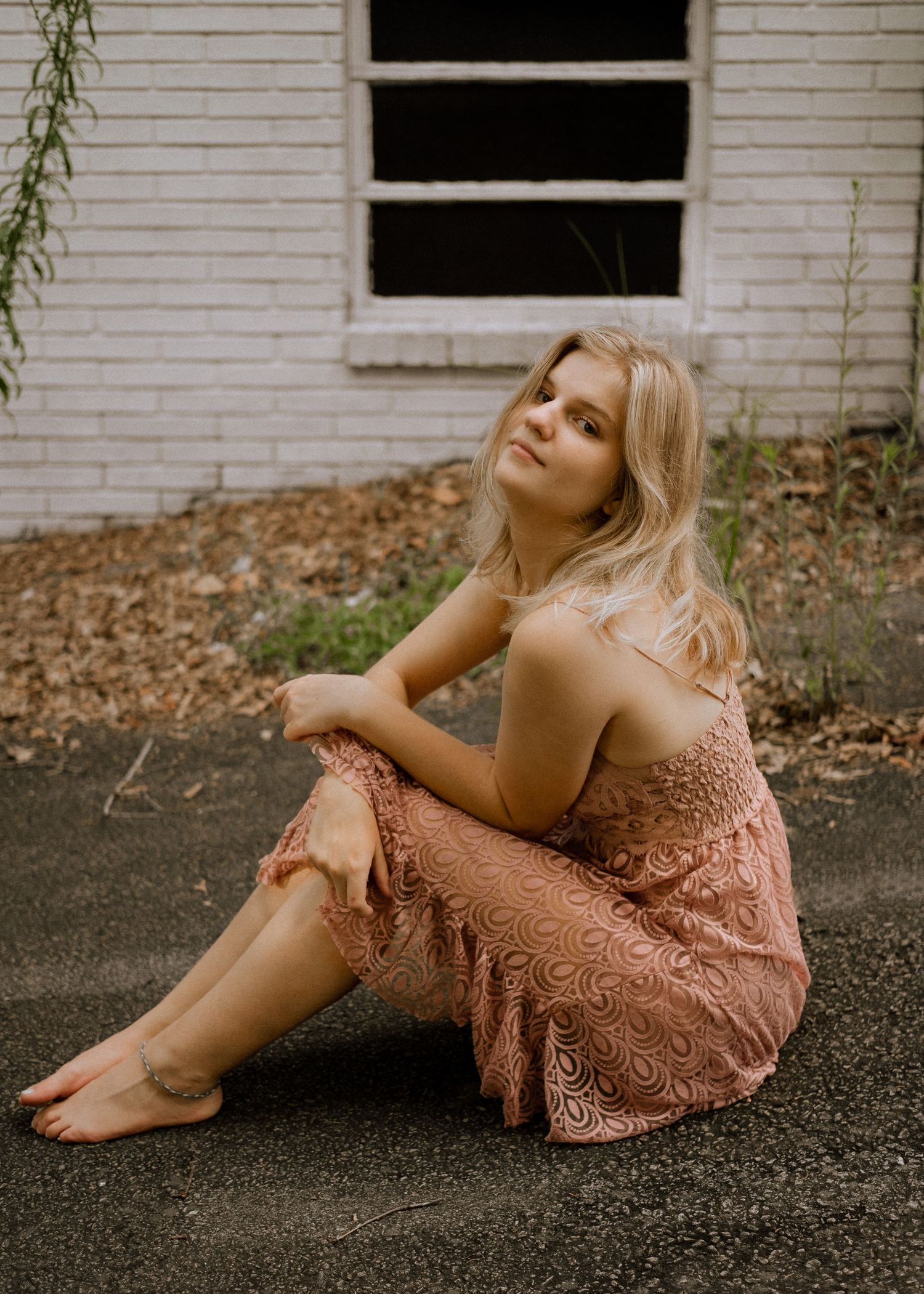 Photo of a girl sitting in front of an abandoned building