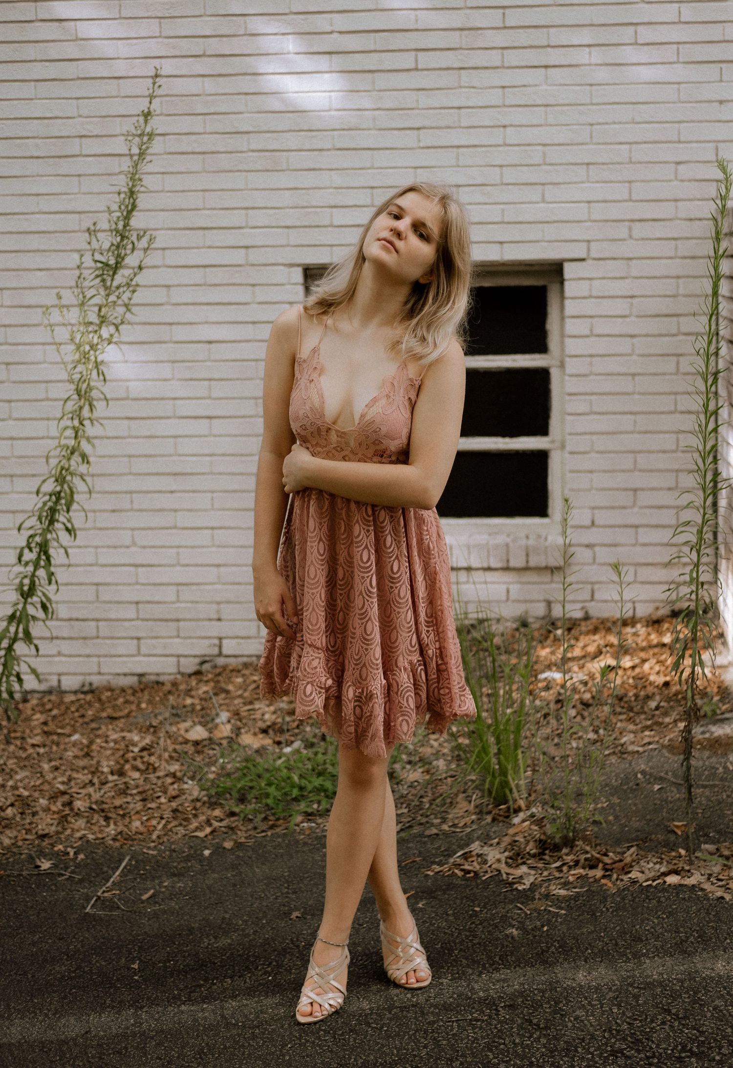 Photo of a girl standing in front of an abandoned building