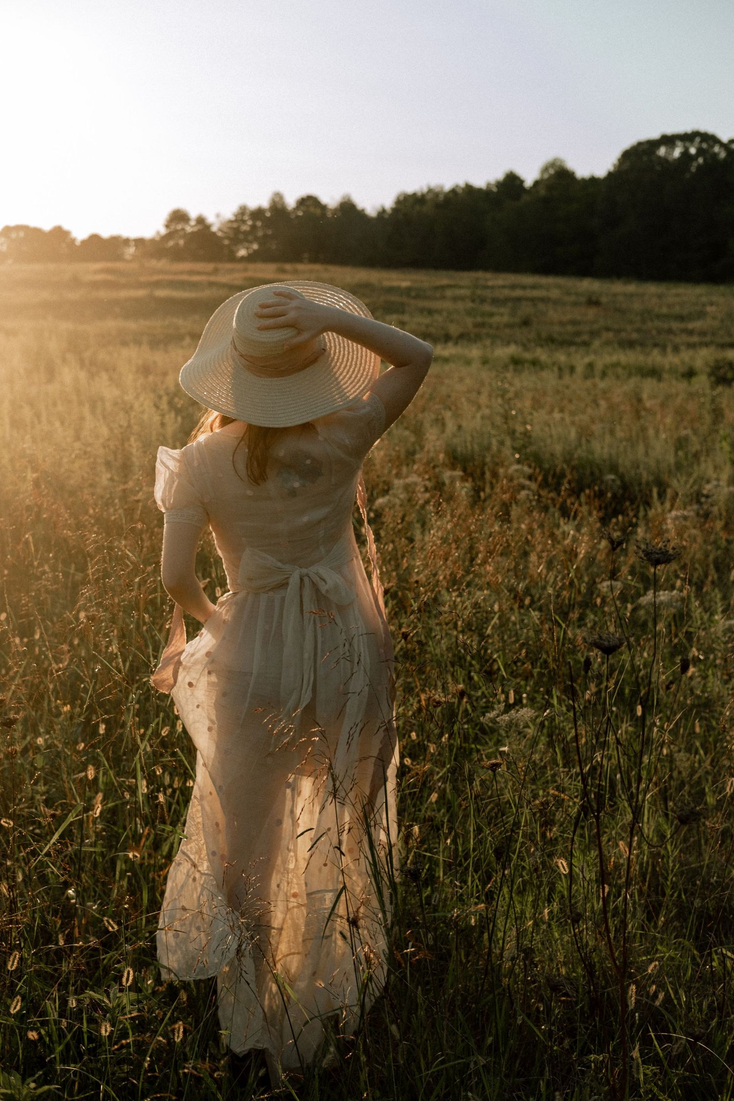 Photo of two girls in a field wearing a vintage dress at golden hour