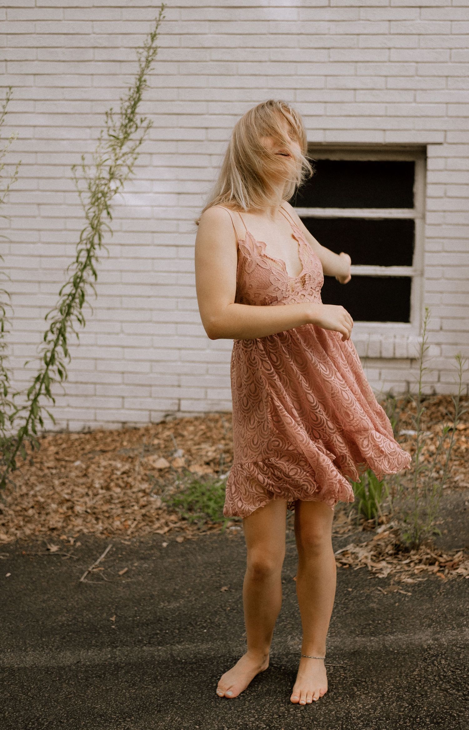 Photo of a girl dancing in front of an abandoned building
