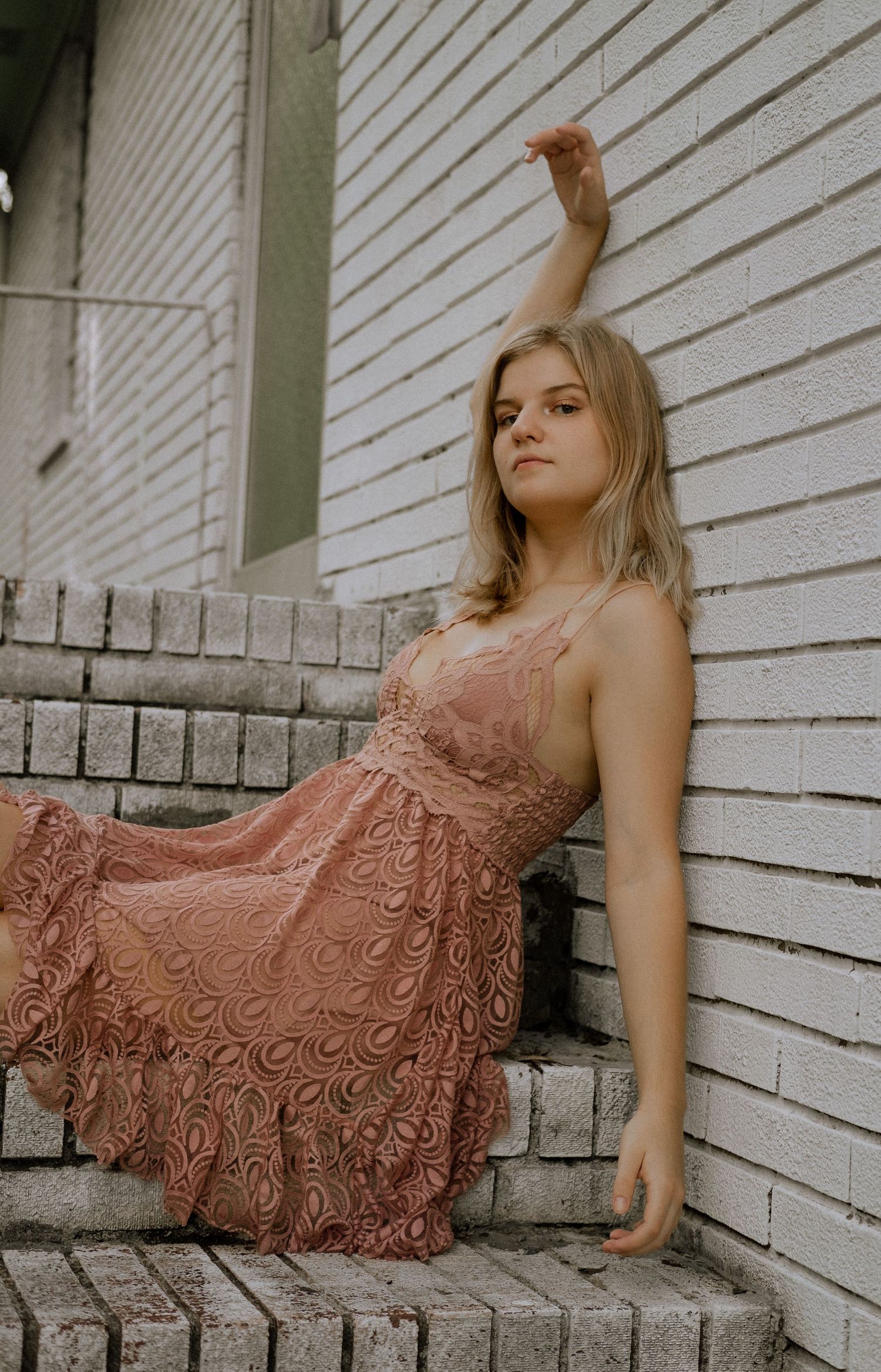 Photo of a girl sitting on the stairs of an abandoned building
