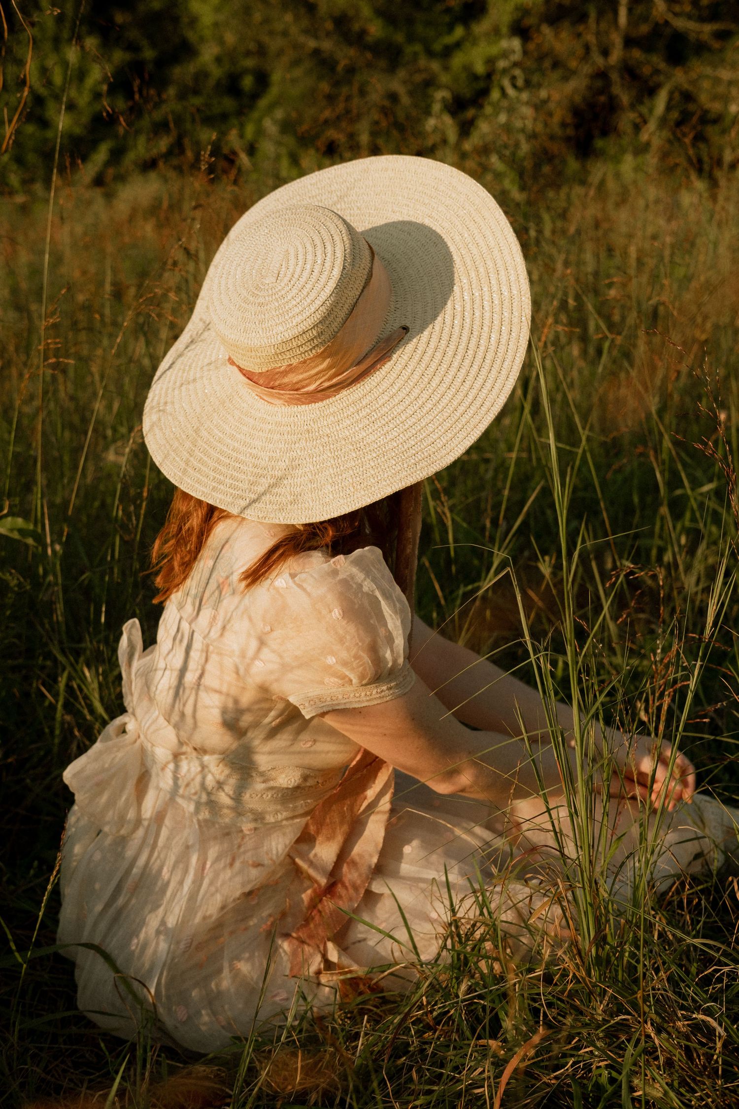 Photo of two girls in a field wearing a vintage dress at golden hour