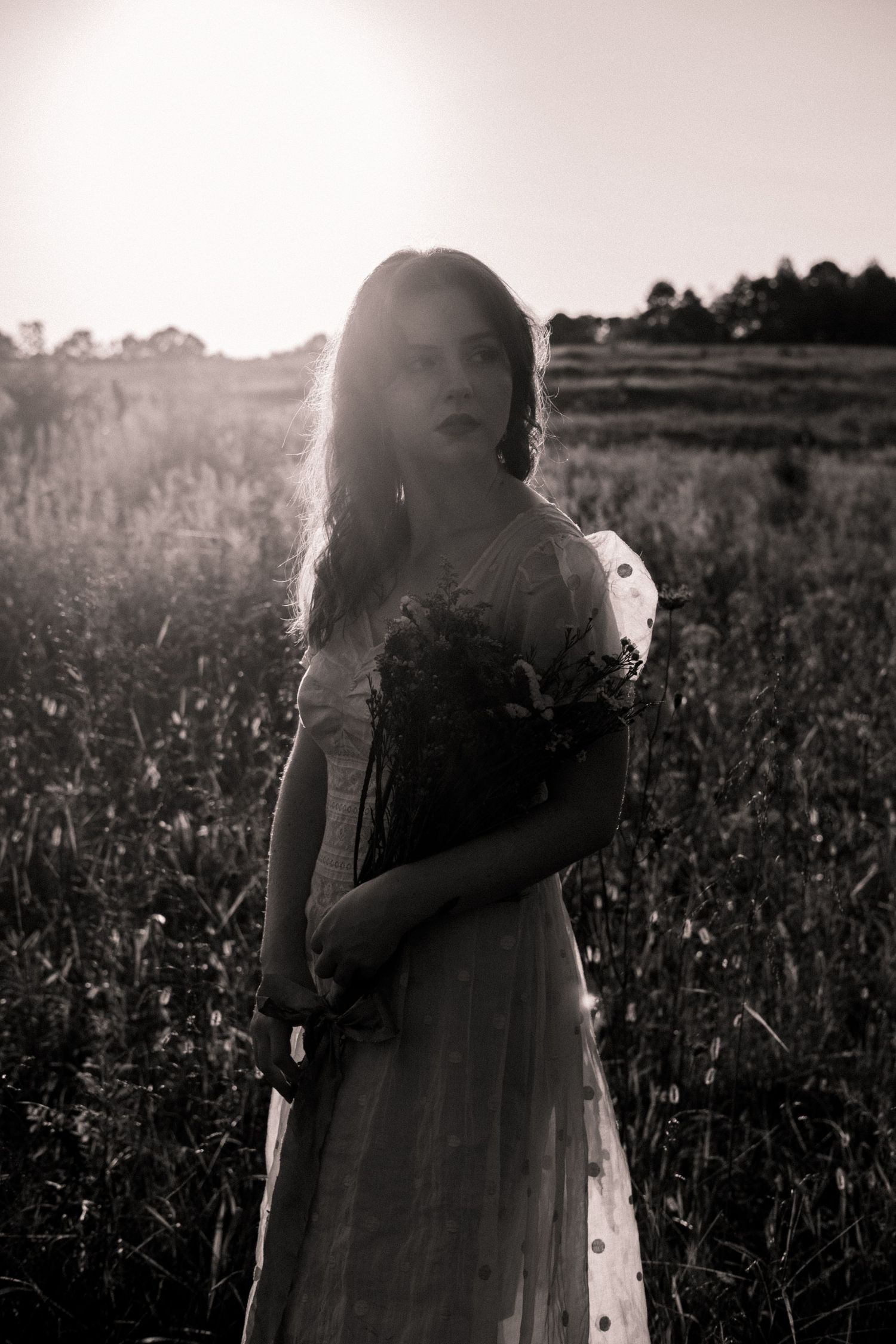 Photo of two girls in a field wearing a vintage dress at golden hour