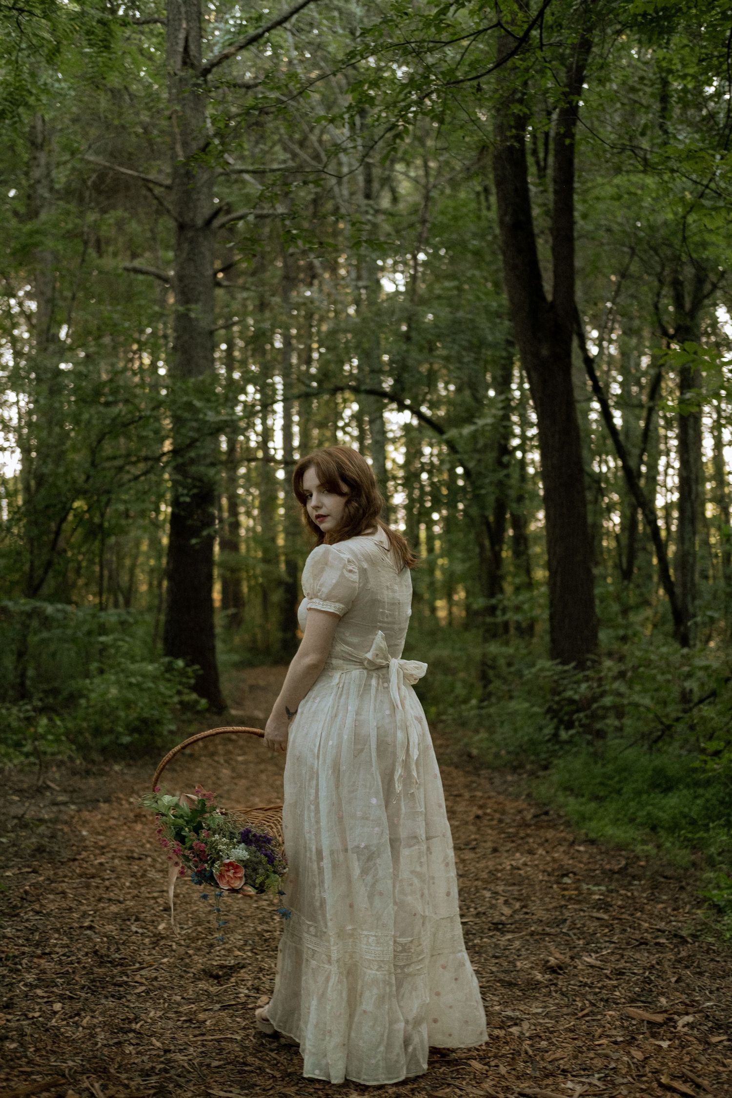 Photo of two girls in a forest wearing a vintage dress