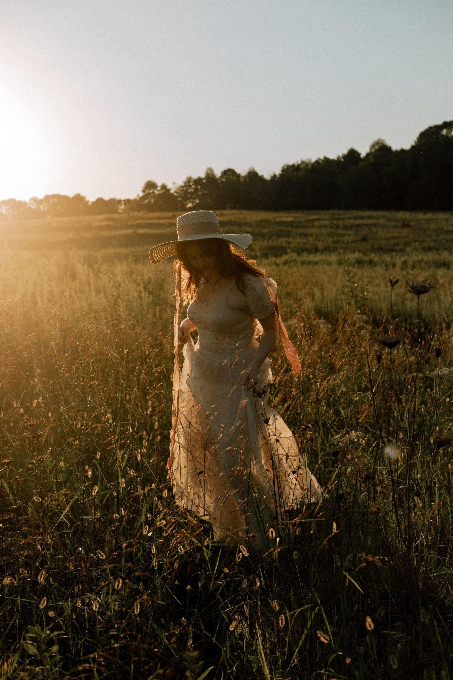 Photo of two girls in a field wearing a vintage dress at golden hour