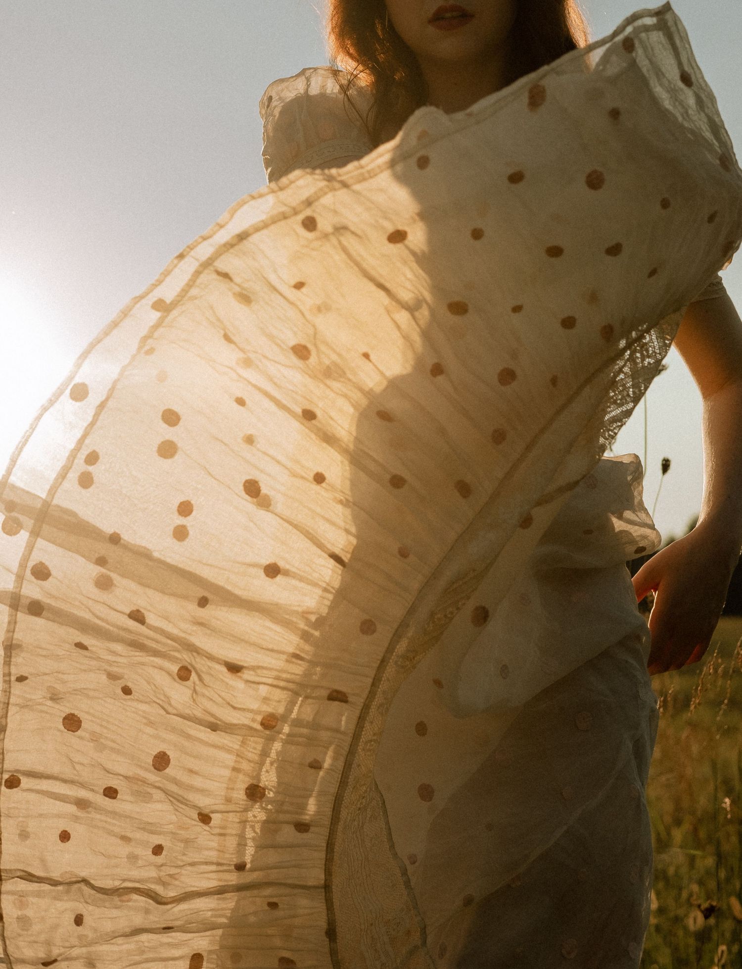 Photo of two girls in a field wearing a vintage dress at golden hour