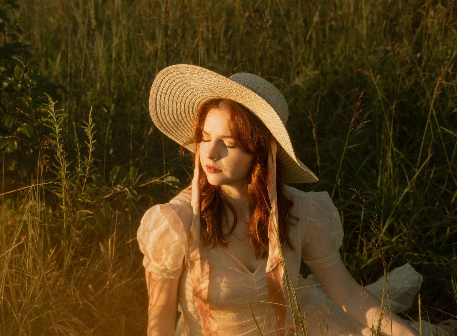 Photo of two girls in a field wearing a vintage dress at golden hour