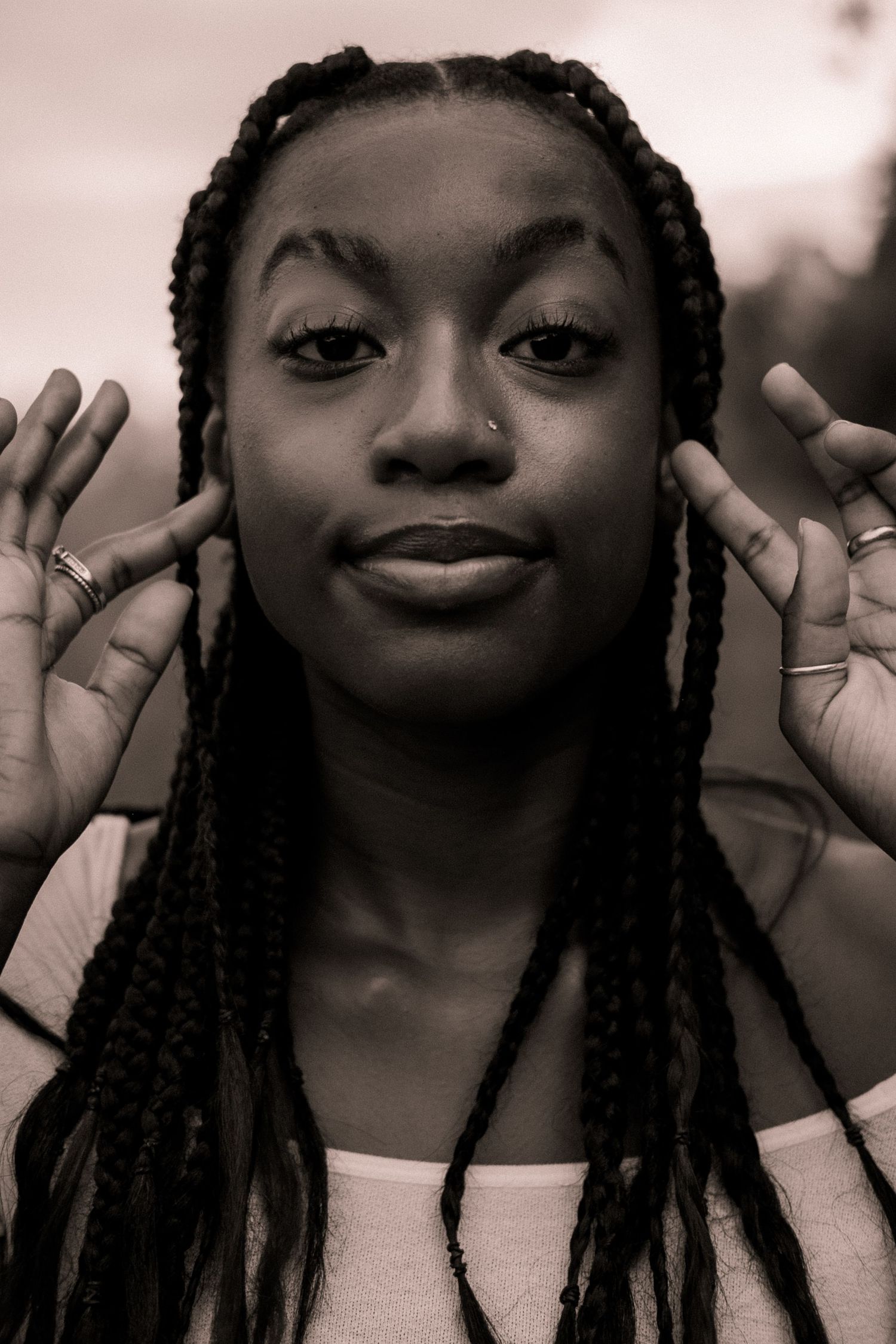 Black and white photo of a girl touching her face