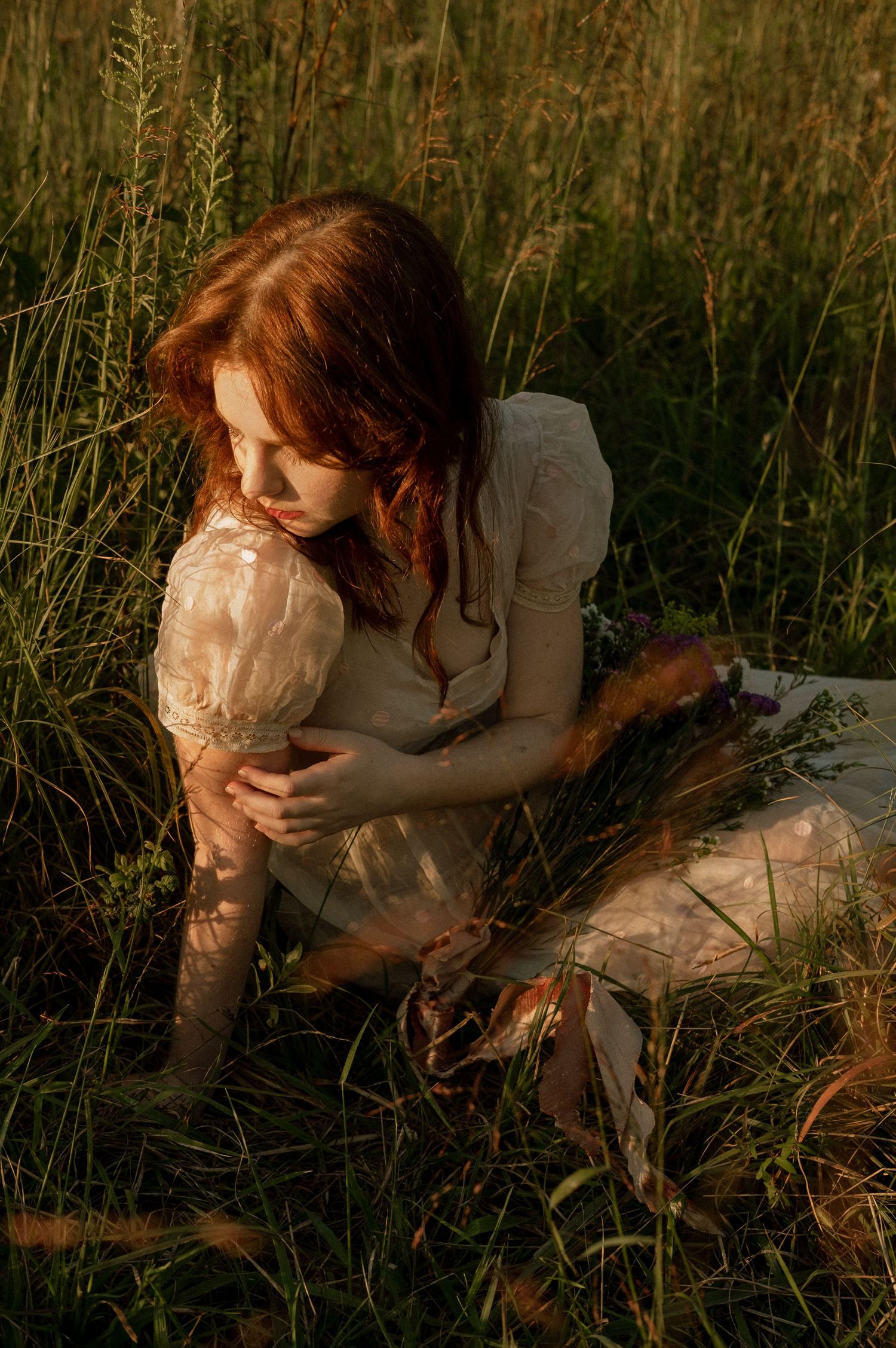 Photo of two girls in a field wearing a vintage dress at golden hour