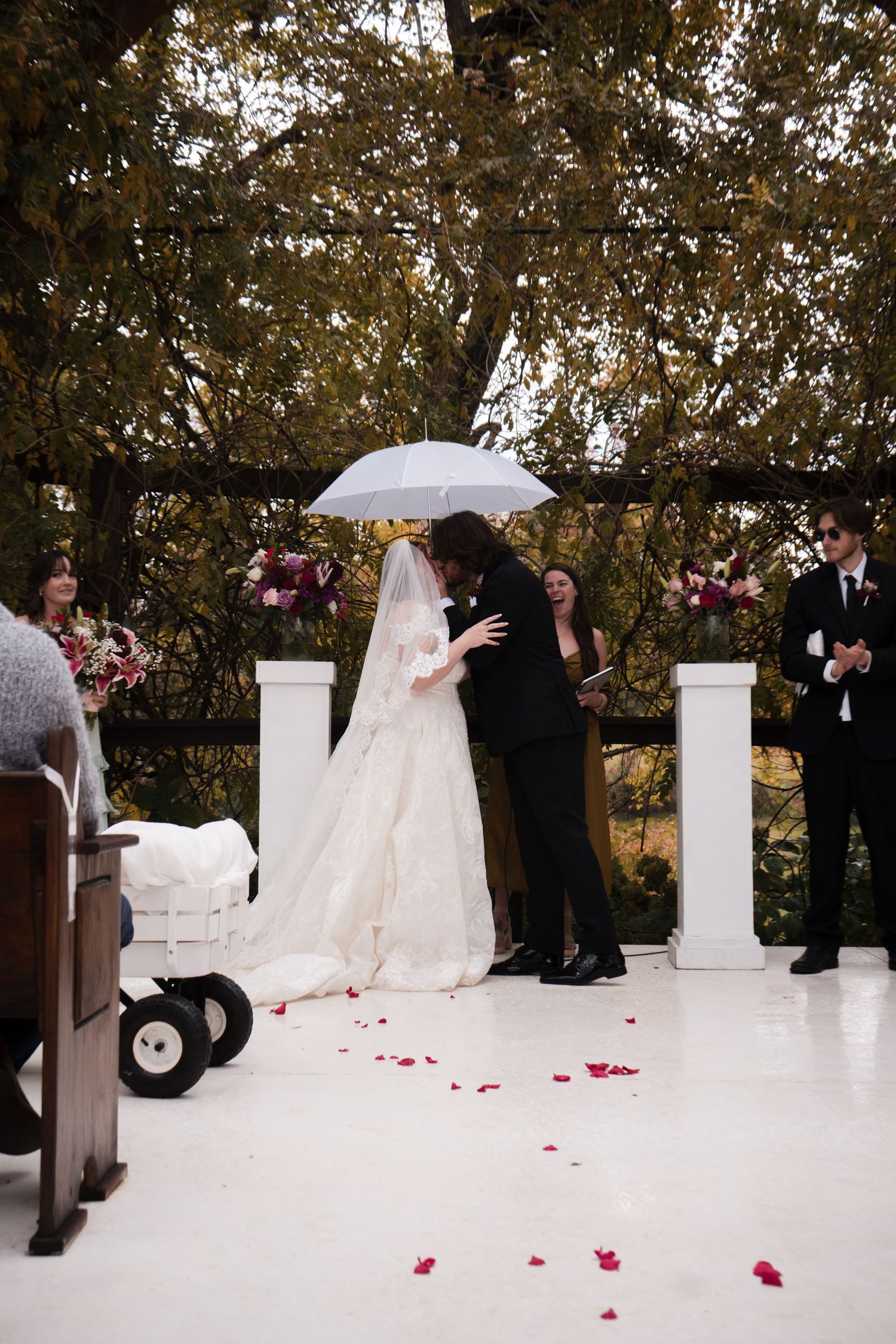 A wedding ceremony sequence shows a couple kneeling at an elegant outdoor venue with white columns and scattered rose petals.