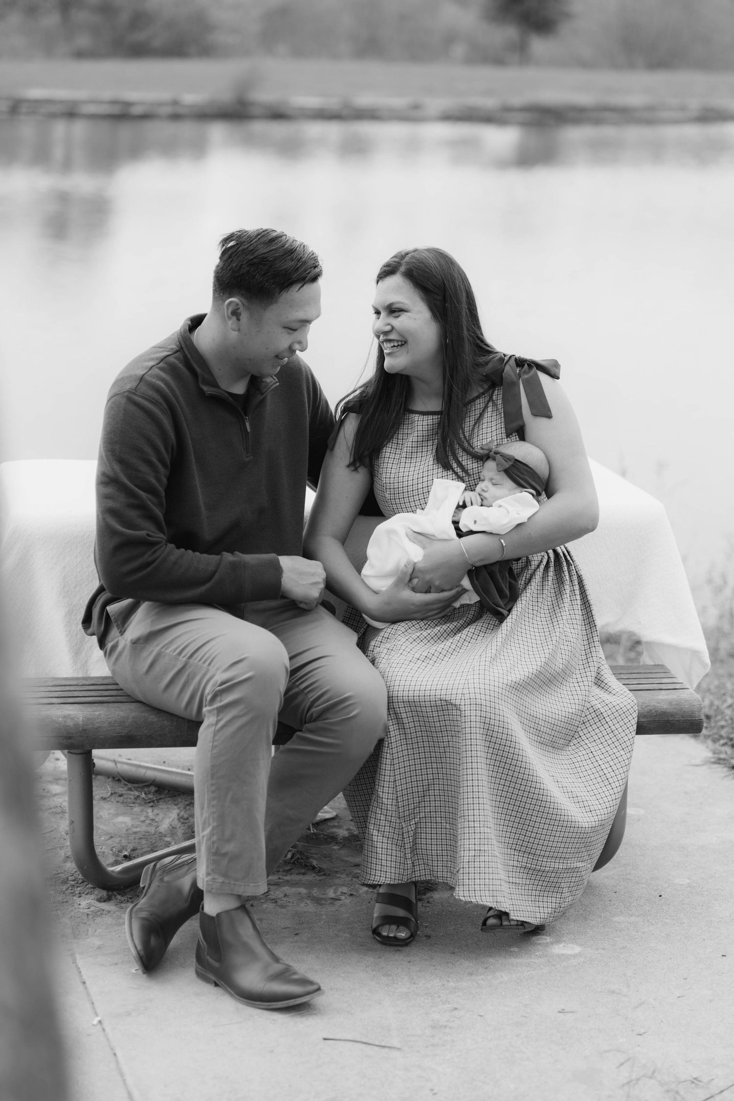 A romantic black and white photo sequence of a couple sitting and laughing together on a bench outdoors.