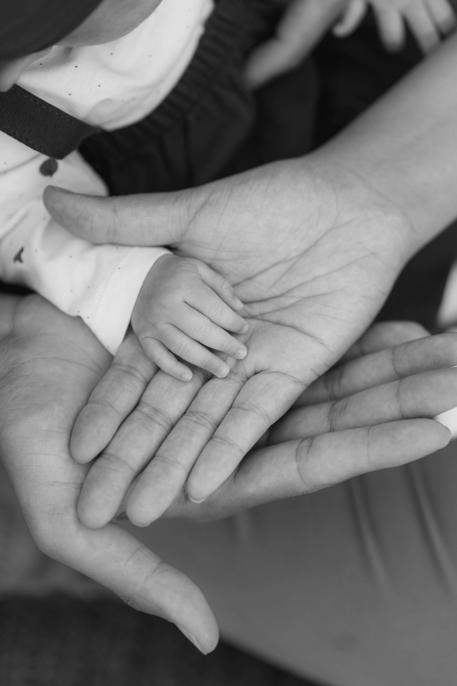 Black and white photo series showing hands joining together in a supportive gesture of unity and connection.