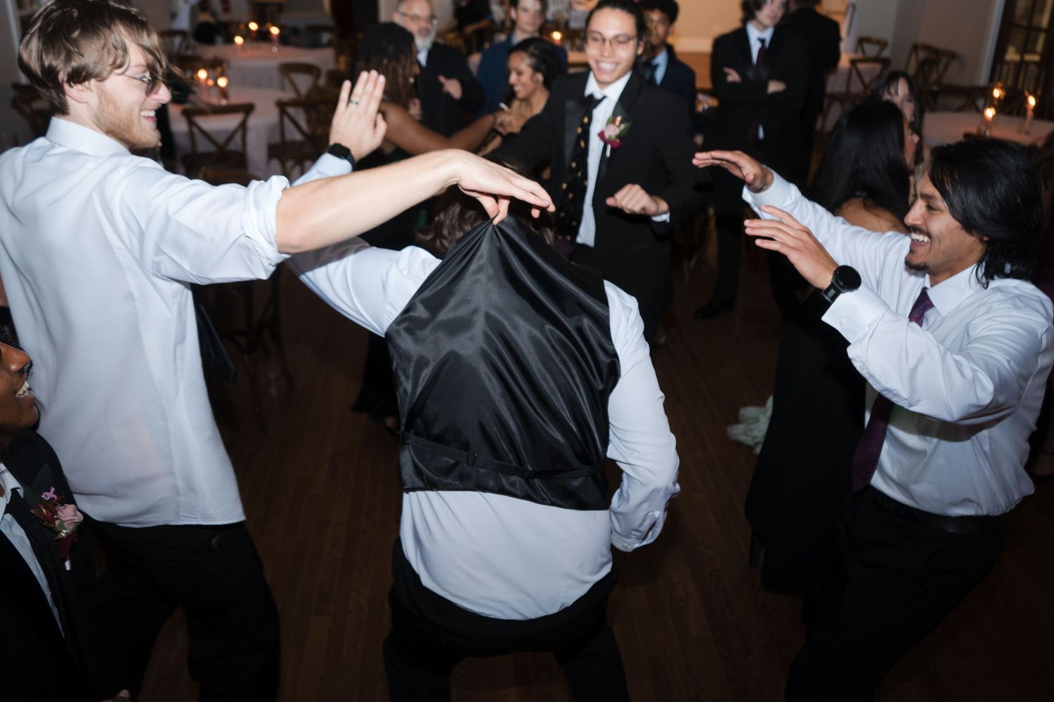 Couples dancing together at a formal event in a dimly lit room.