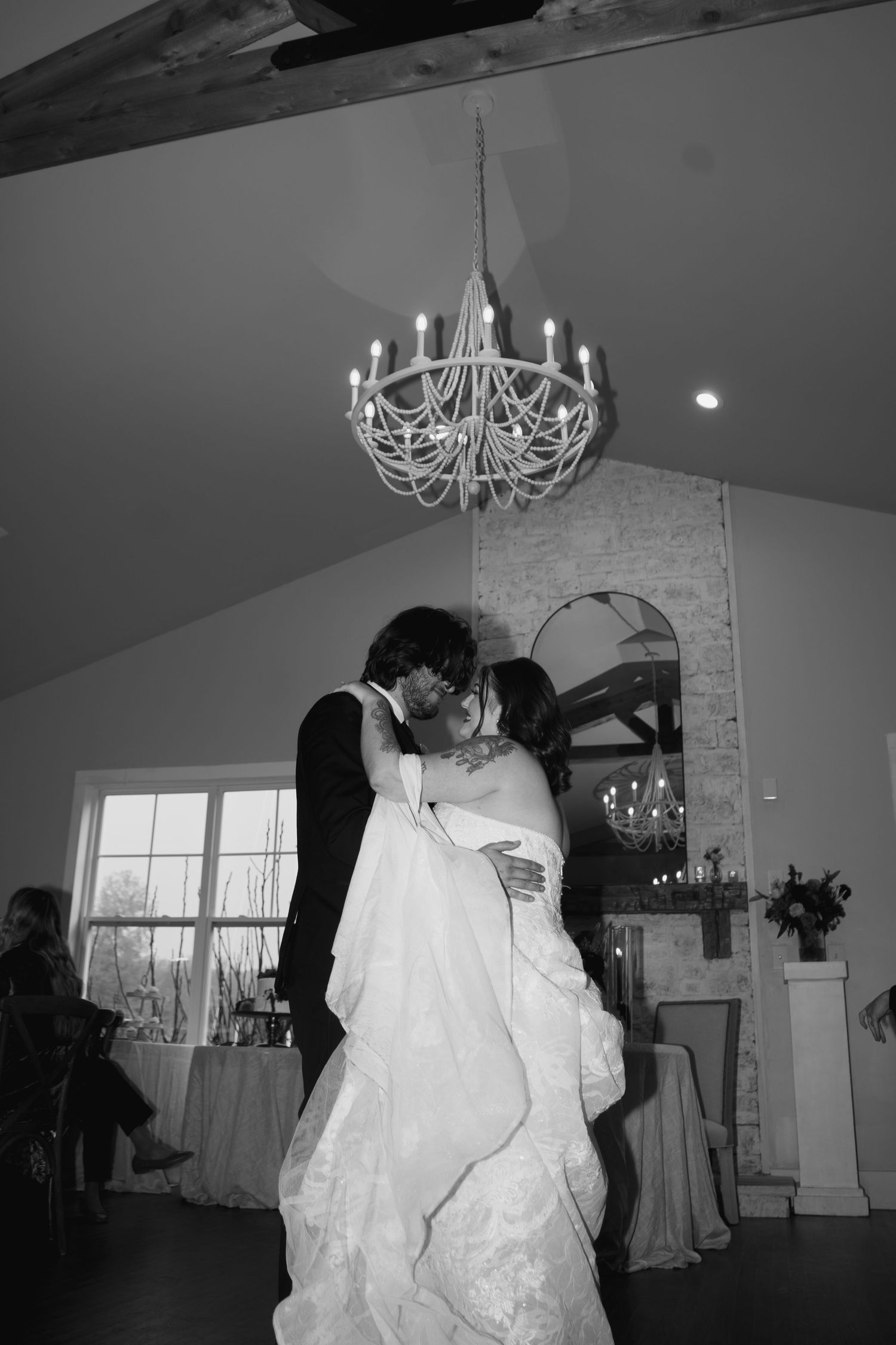 Black and white photos of first dance under elegant chandeliers.