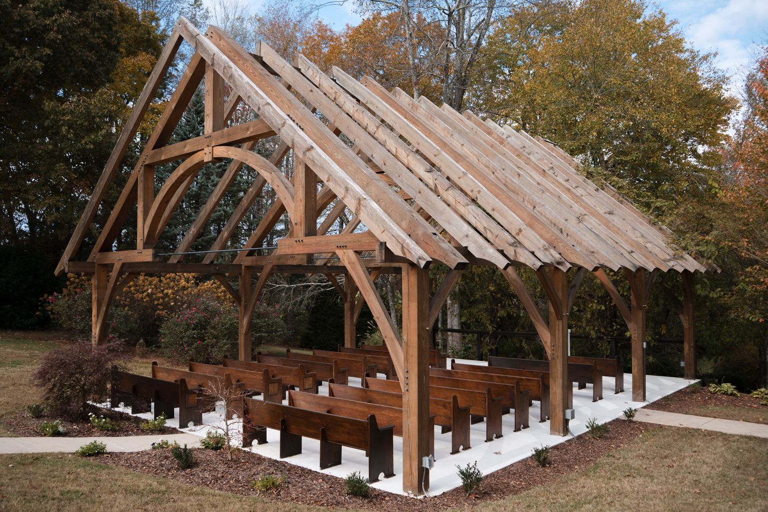 Timber frame construction sequence showing wooden beams and rafters being assembled into a rustic outdoor structure.