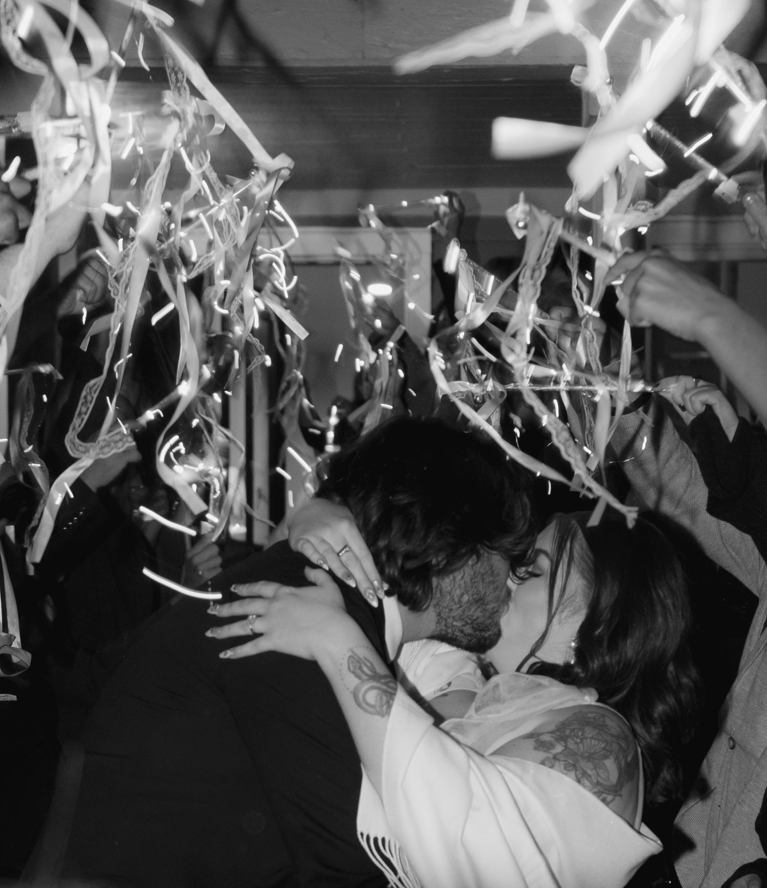 Black and white photo of wedding reception dance floor with streamers and party lights.