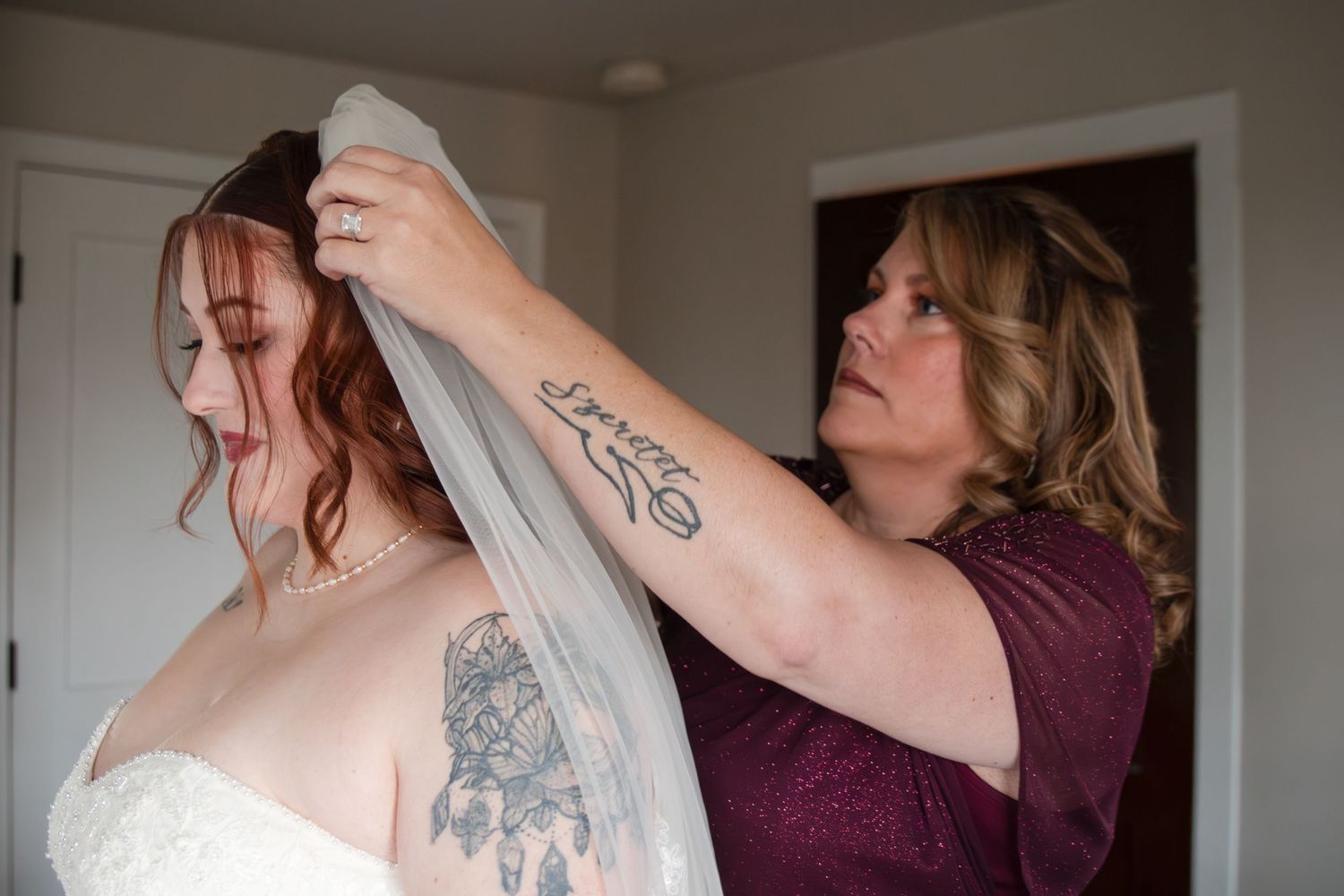 A bride getting ready for her wedding day with a veil being placed on her head.