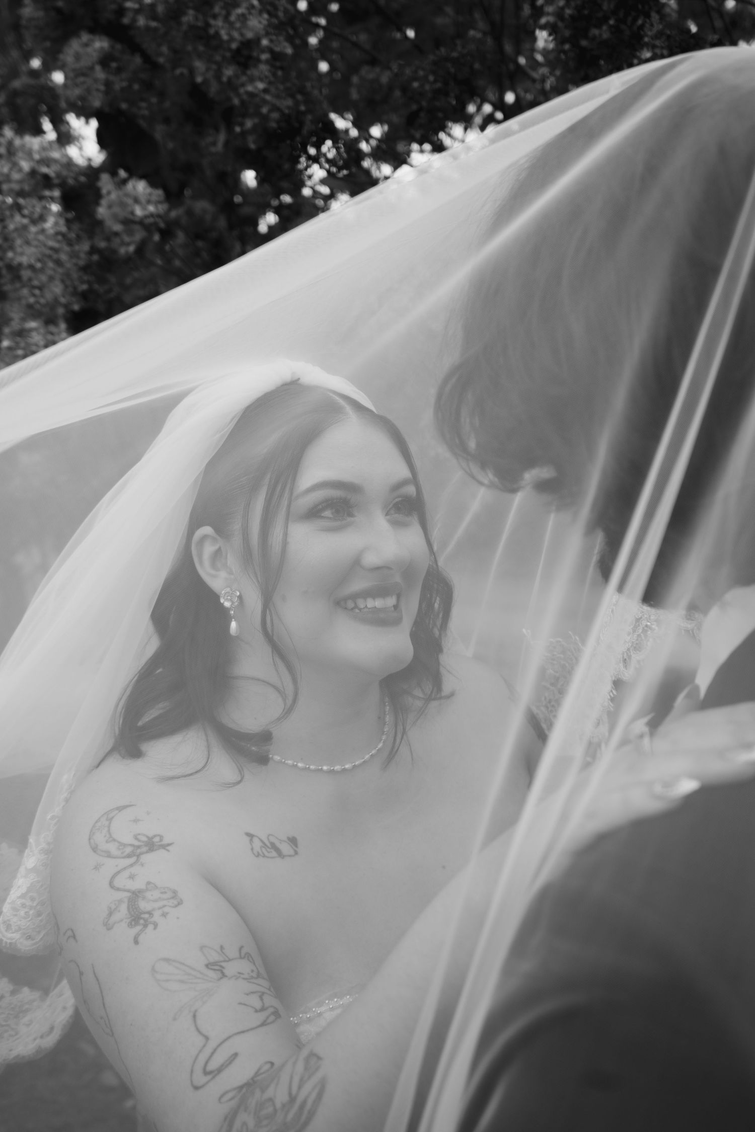 A bride wearing a delicate veil is captured in an artistic black and white photo series showing different expressions.