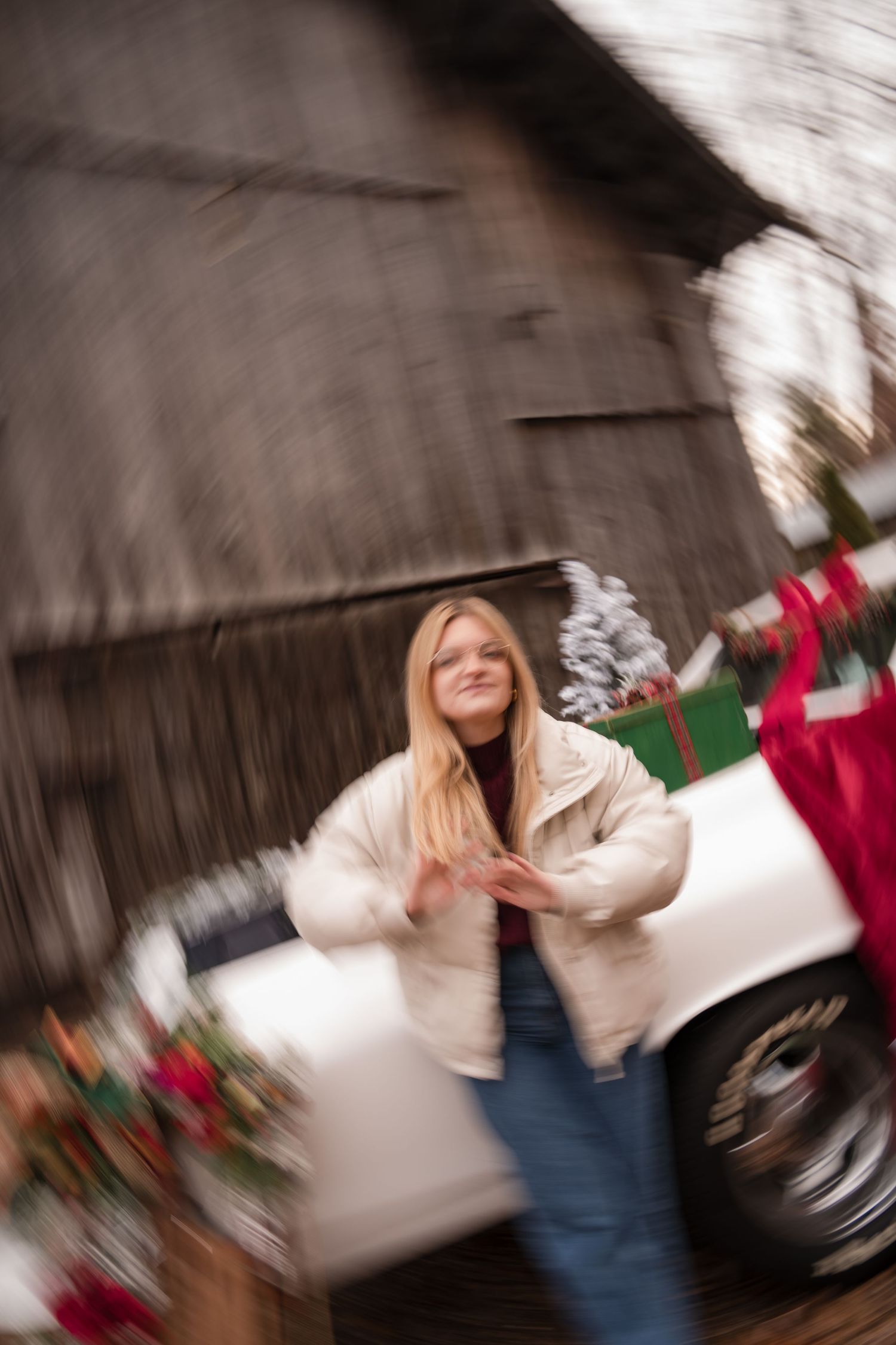Motion blur sequence shows a person in blue jeans and white sweater spinning around in a festive holiday setting.
