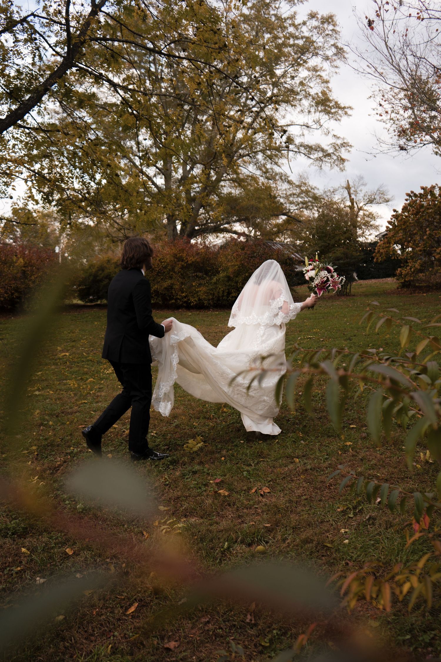 A flowing white wedding veil catches the autumn breeze as it billows dramatically in the wind.