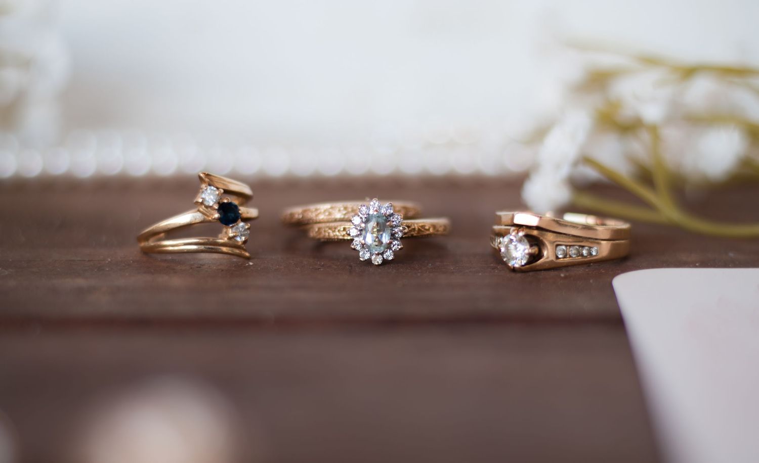 Close-up of elegant wedding rings and bands arranged artistically on a neutral surface.