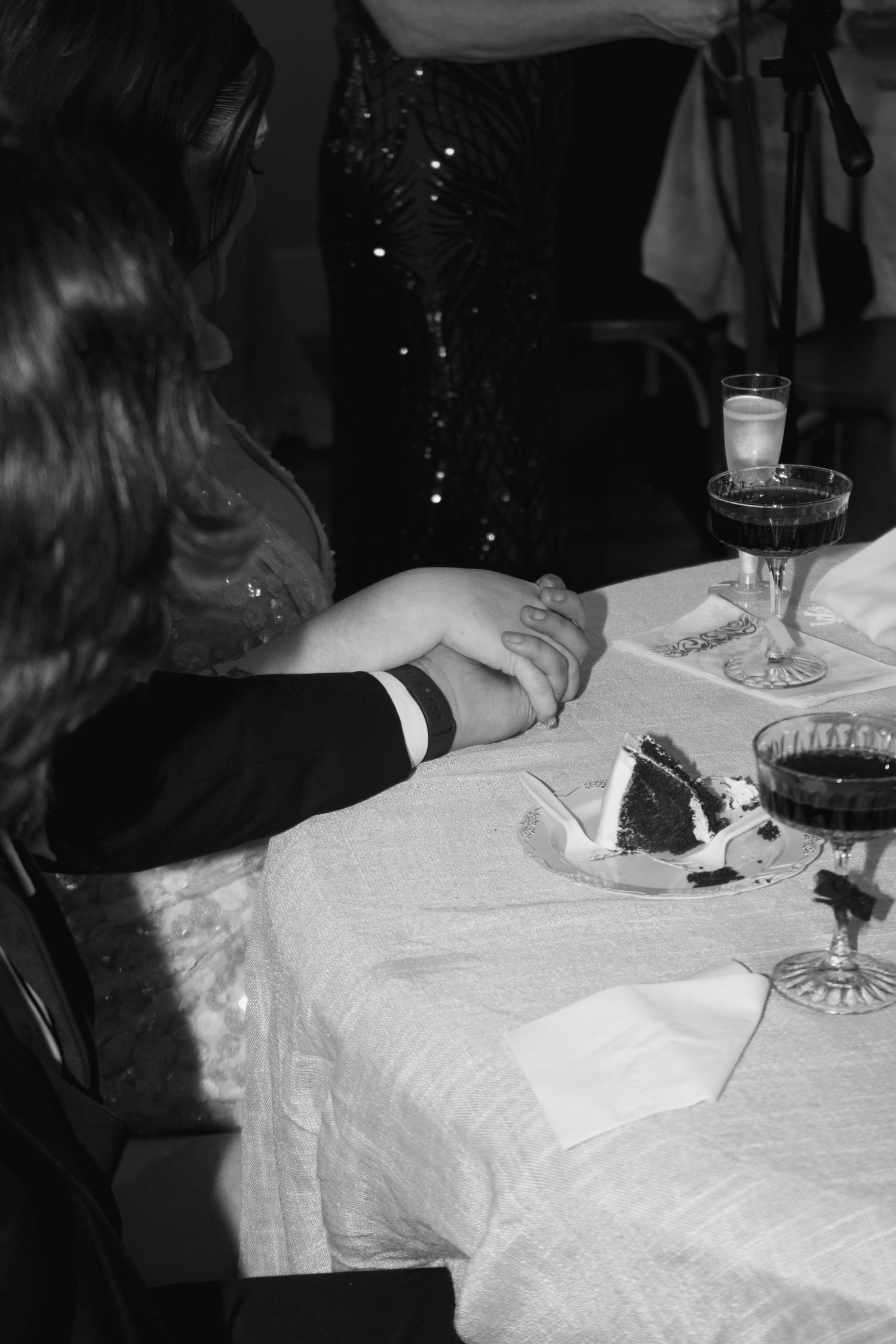 Black and white close-up shots of hands signing documents on a white tablecloth.
