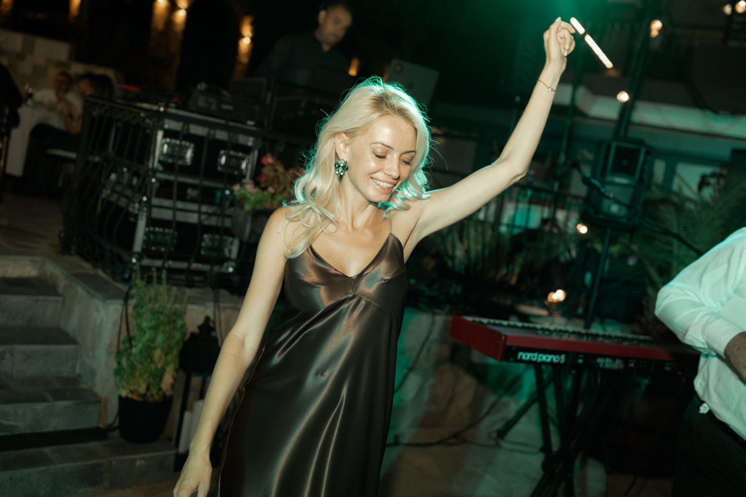 Seven sequential photos show a dancer in a brown dress performing dynamic movements in a dimly lit venue.