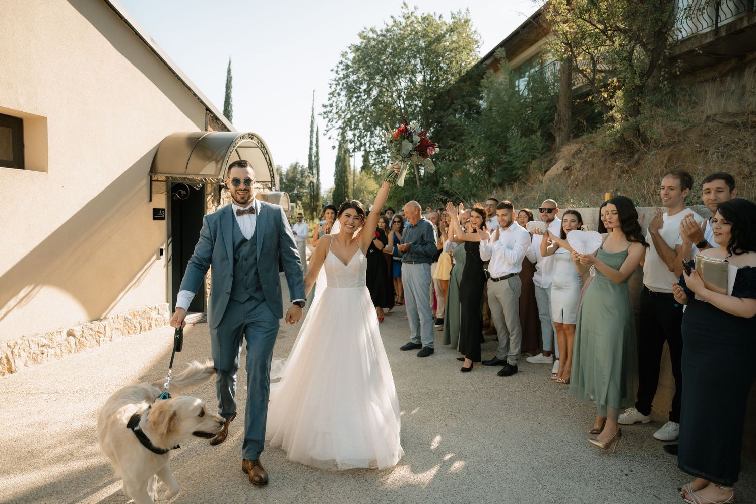 Wedding guests form a celebratory line outdoors as newlyweds walk through with sparklers lighting up the evening.